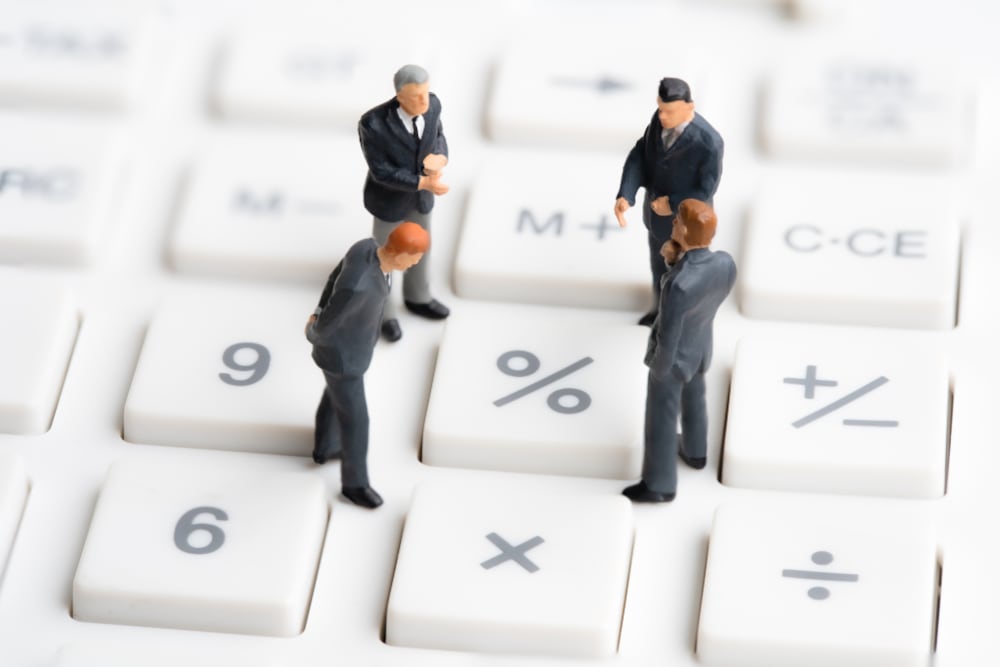 Miniaturas de personas sobre teclas de cálculo fiscal, simbolizando el ajuste al impuesto sobre la renta en Costa Rica en 2025.