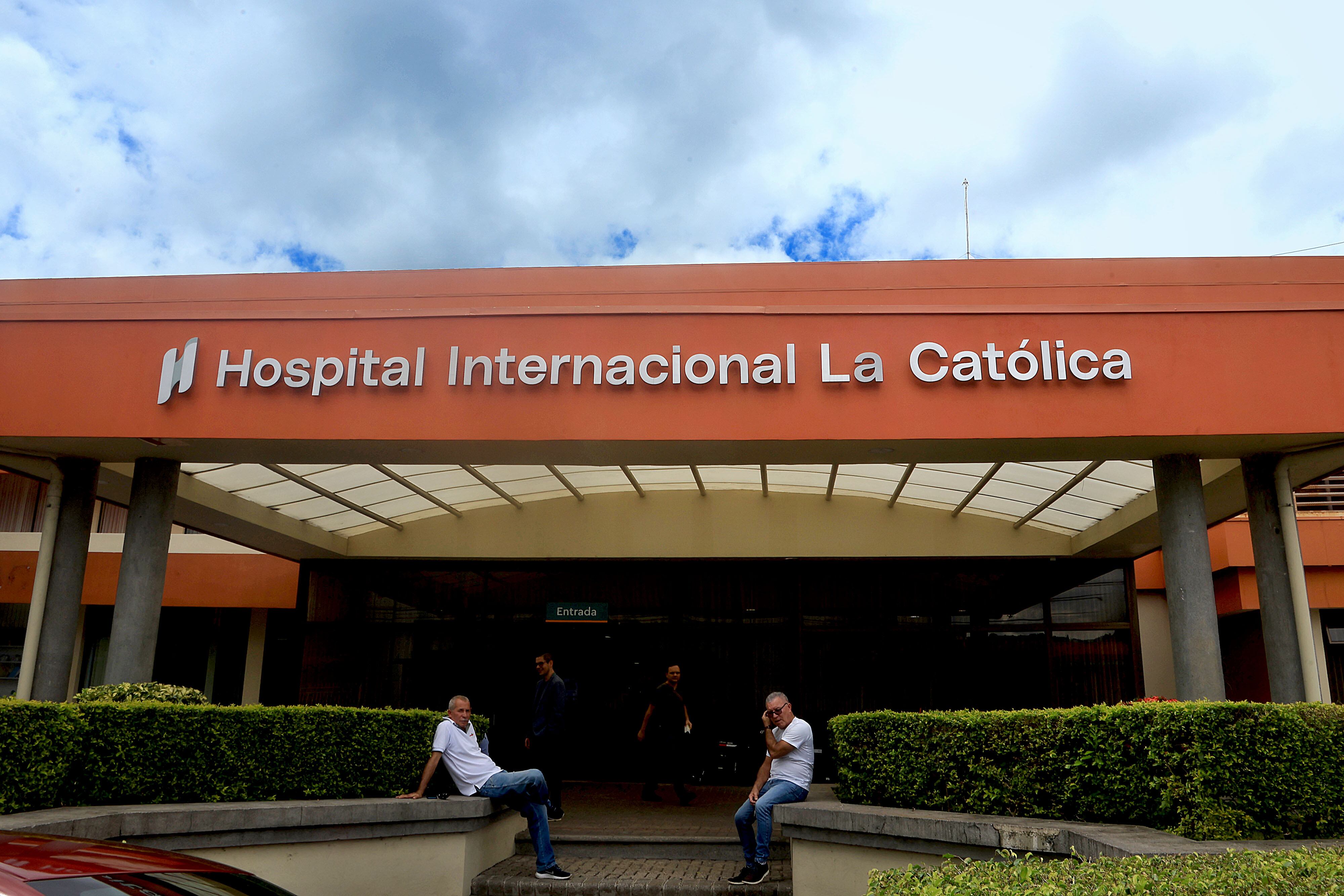 Vista exterior del Hospital Internacional La Católica en Costa Rica, con su entrada principal y el rótulo del hospital visible en la fachada.