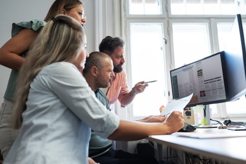 Equipo de periodistas trabajando en la redacción, revisando documentos impresos y digitales, simbolizando el compromiso del periodismo con la verdad sobre los hechos.