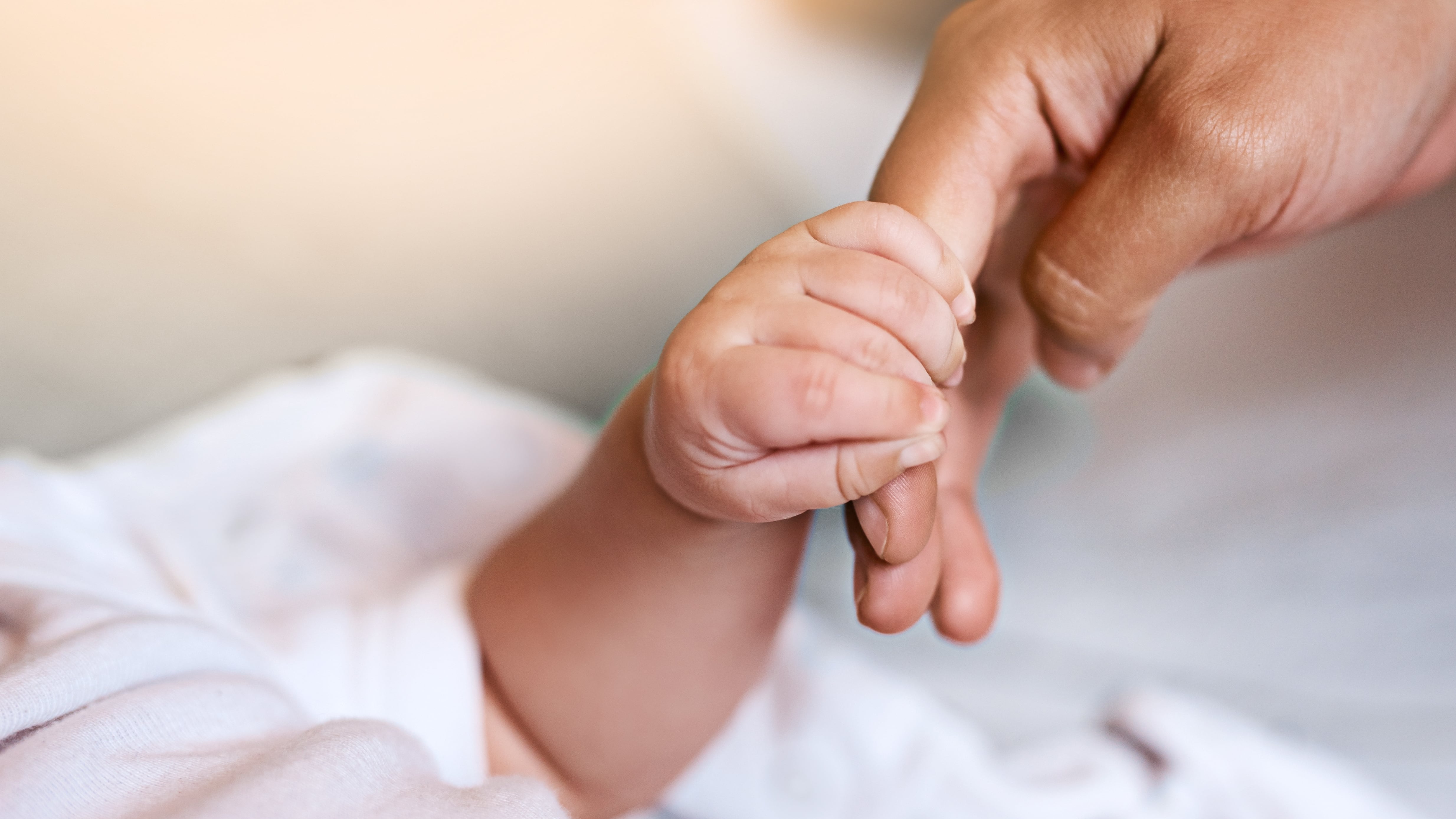 Mano de bebé recién nacido con una mano adulta