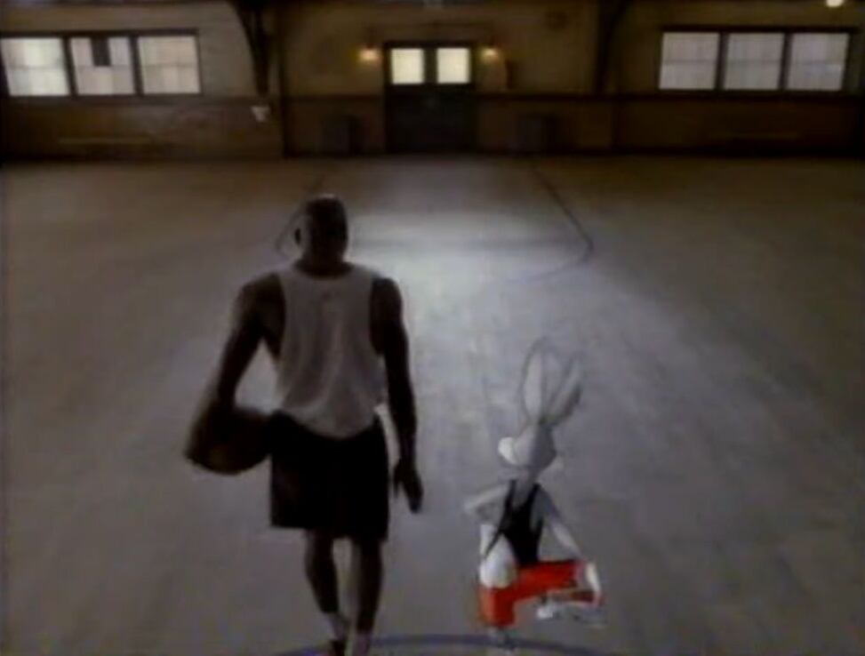 Michael Jordan de espaldas caminando con Bugs Bunny hacia la salida de un gimnasio de baloncesto