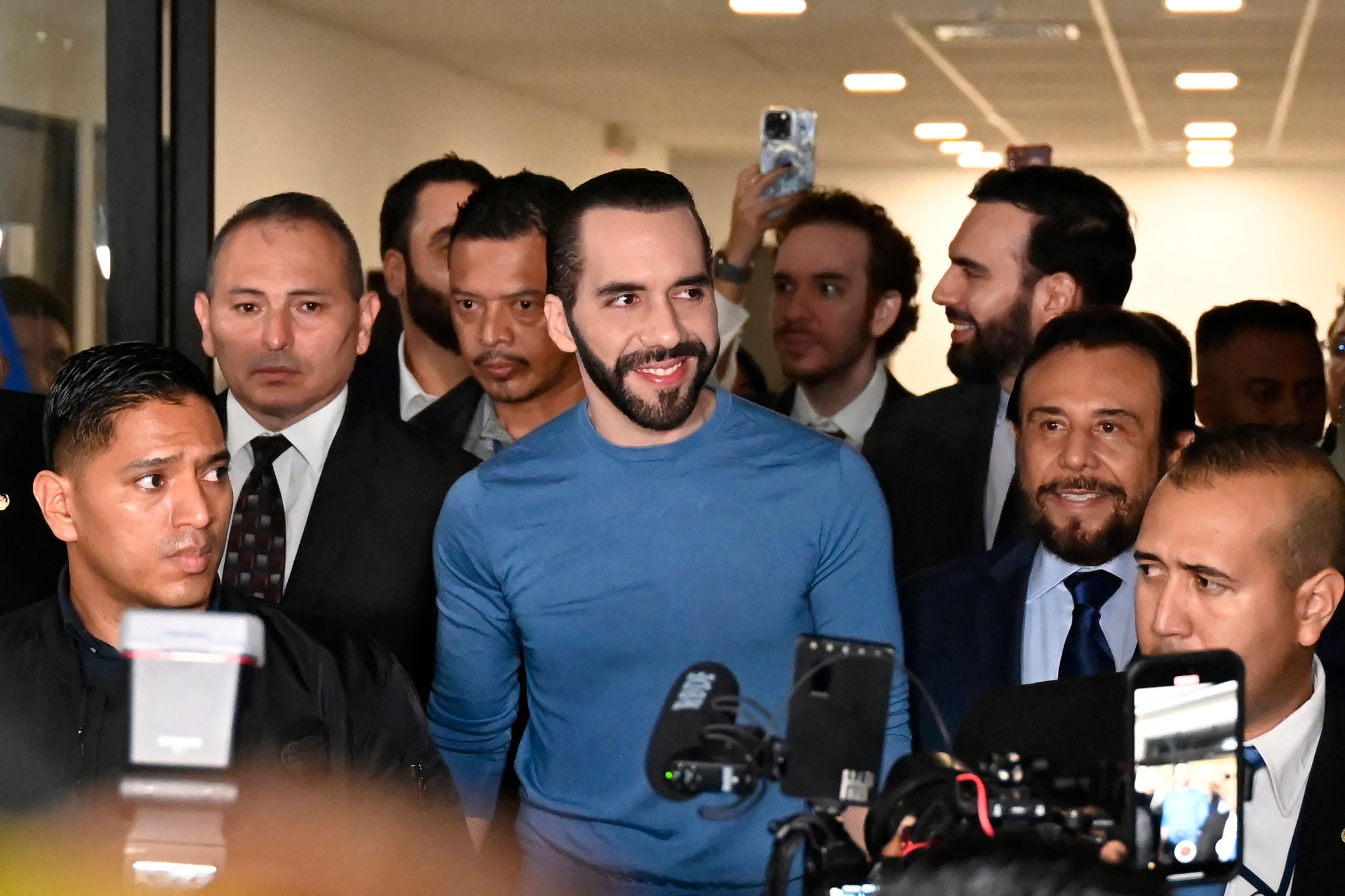 El presidente de El Salvador, Nayib Bukele (C), sonríe al llegar a la sede del Tribunal Supremo Electoral para registrarse para las próximas elecciones, en San Salvador.
