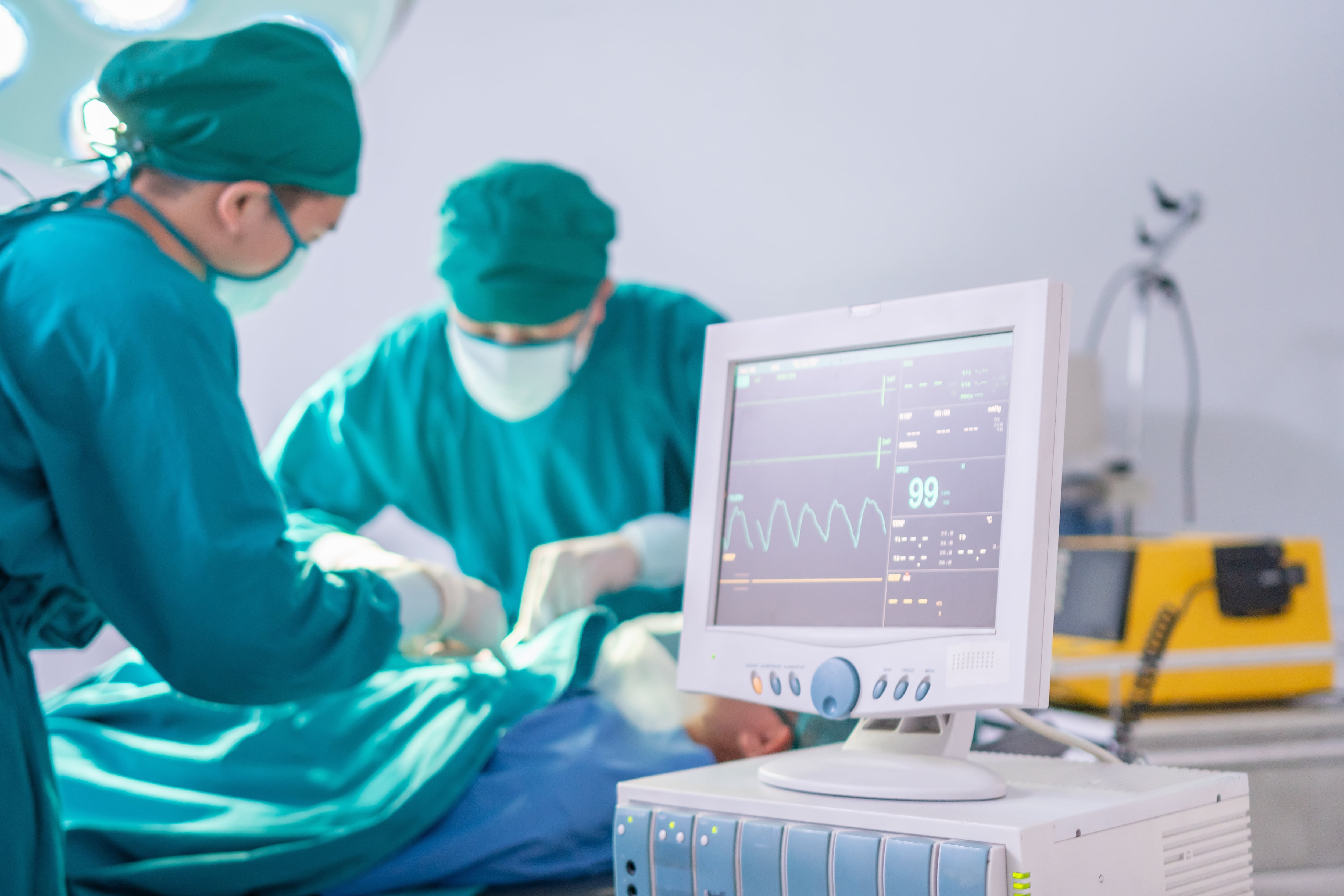 Quirófanos. Procedimiento médico a cargo de doctores a un paciente con monitores de signos vitales.