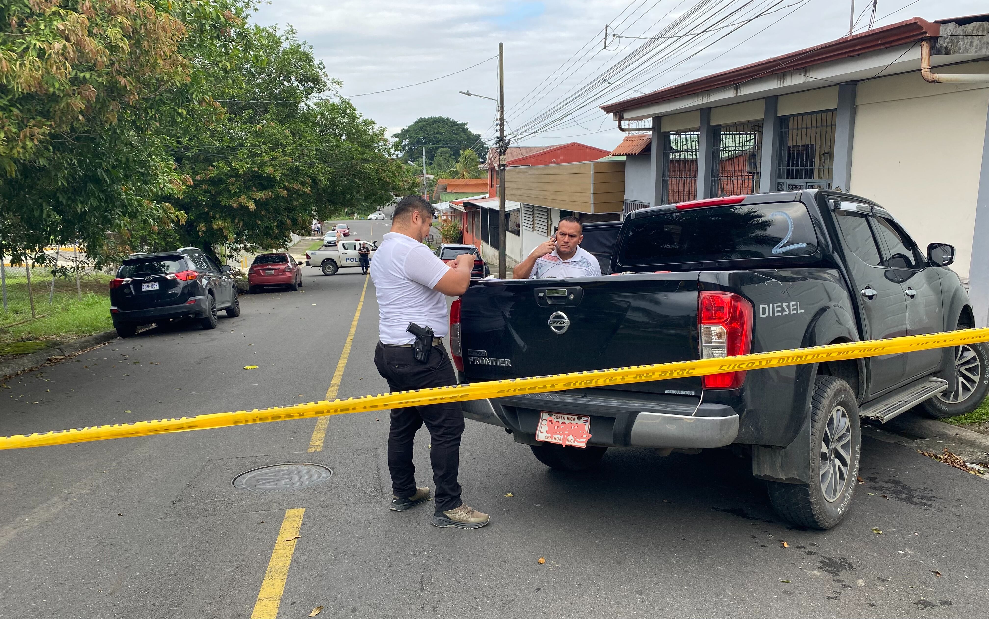 En el automóvil rojo que se ve al fondo permanecía el hombre que fue baleado por motorizados en Limón. Entró en condición delicada al Hospital Tony Facio. Foto: Raúl Cascante.