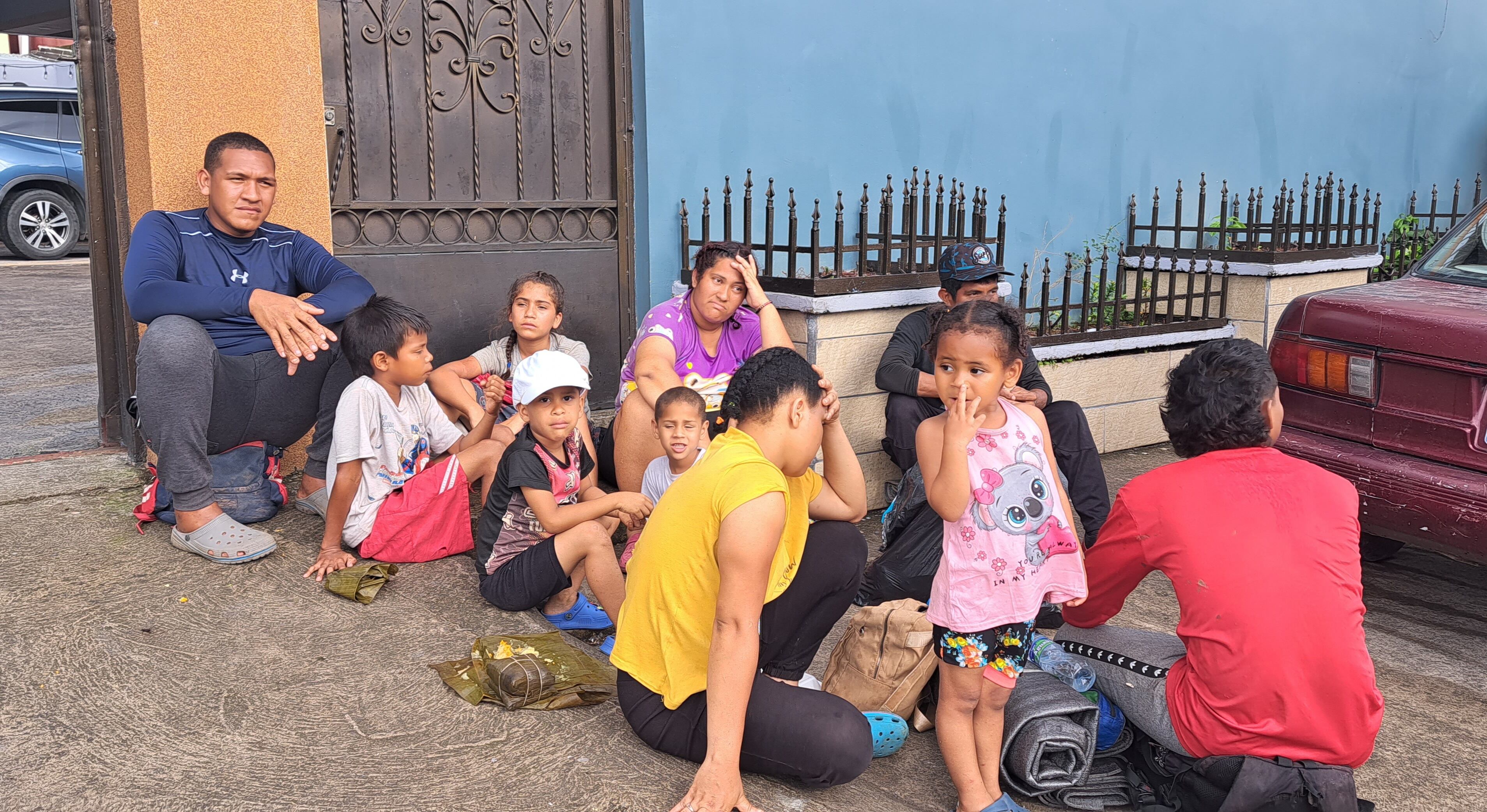 Jason Rentería, junto a su esposa Dailis y su hija Victoria se refugian frente a la cochera de una casa en Paso Canoas mientras consiguen dinero para seguir su camino. Foto:Patricia Recio.