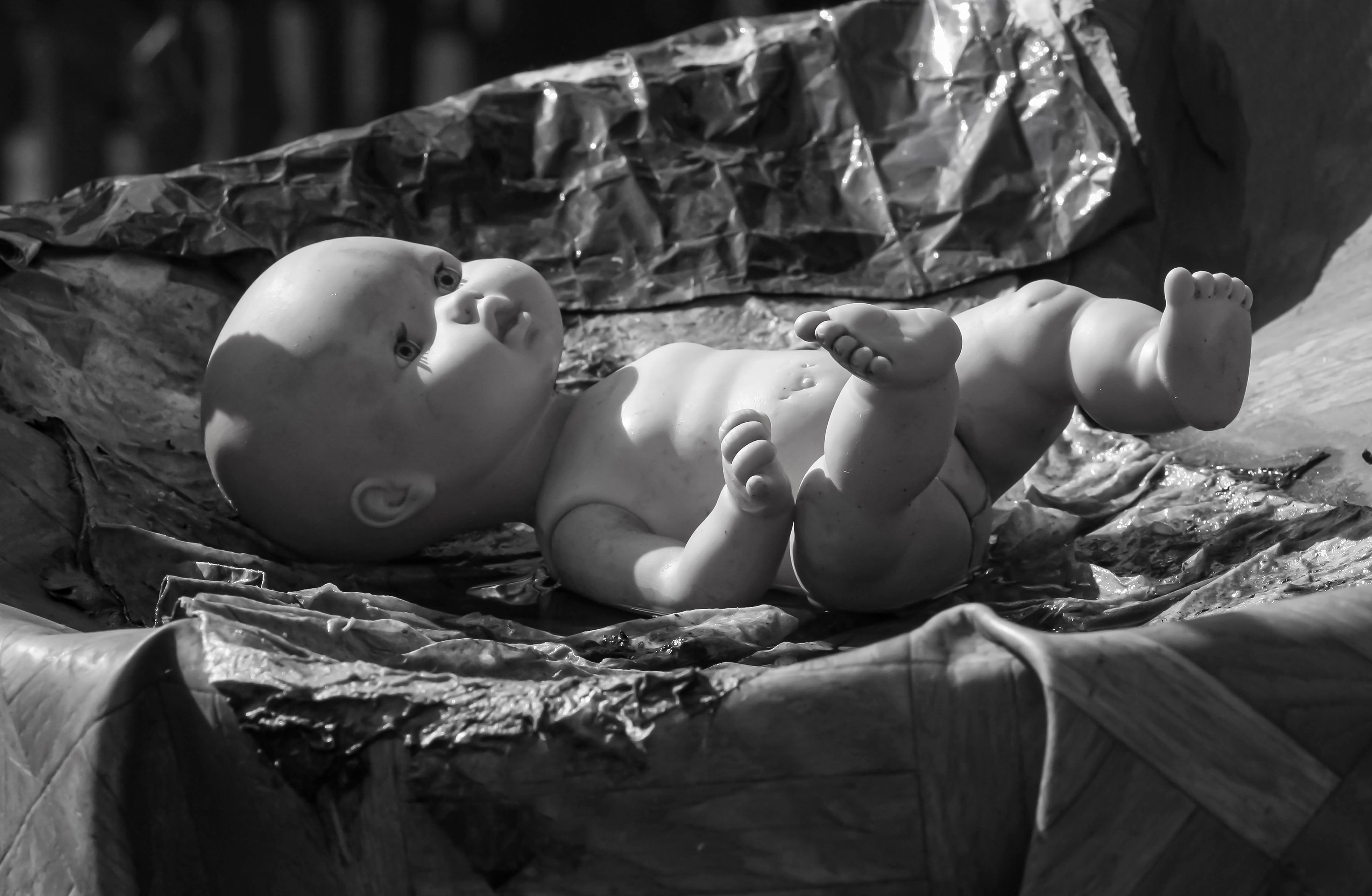 En blanco y negro, un muñeco bebé tirado sobre el piso.
Fotografía: Shutterstock