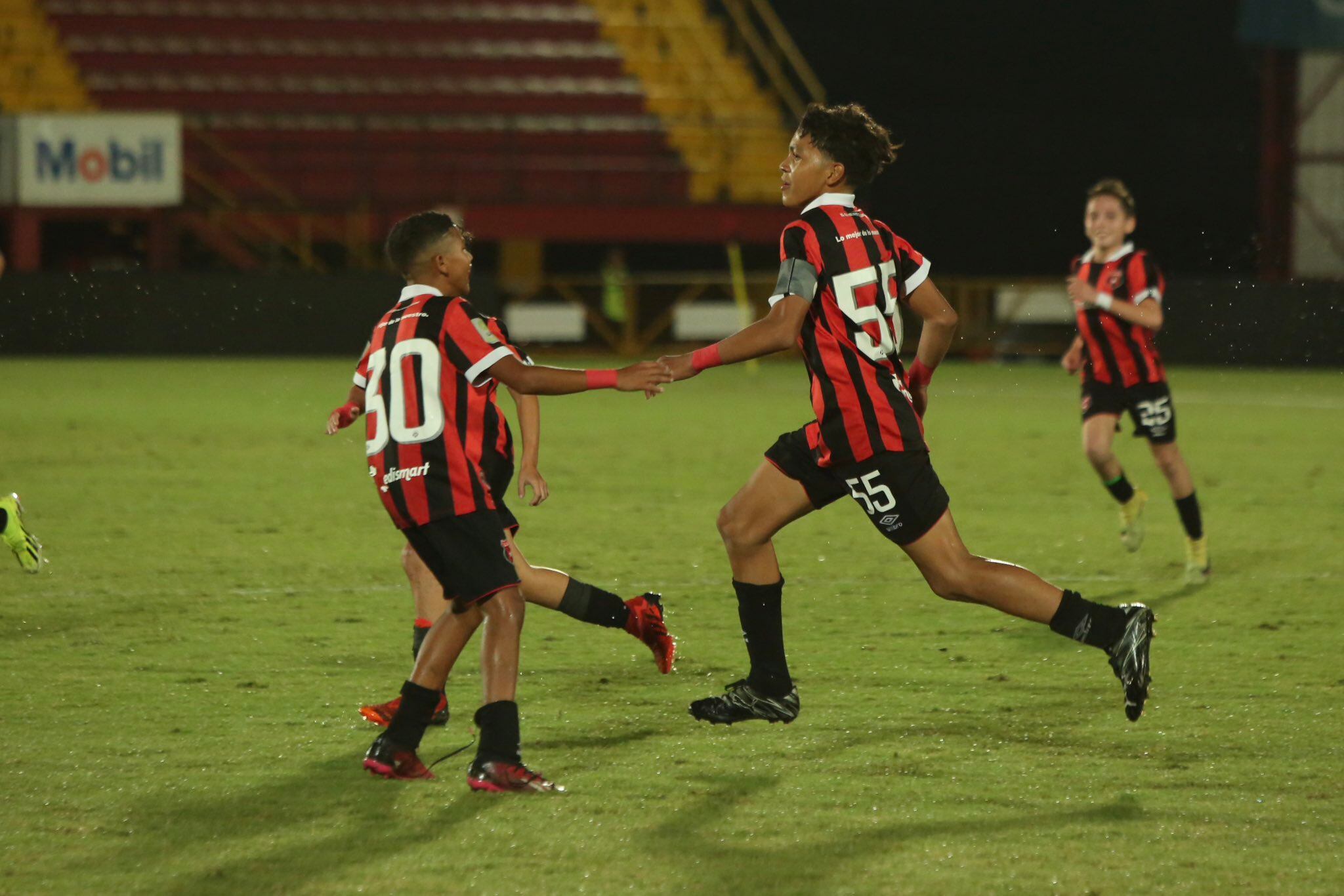 David Molina (55) marcó un doblete en el partido de vuelta de la final U-12 entre Liga Deportiva Alajuelense y Saprissa. James Warren (30) estrecha su mano.