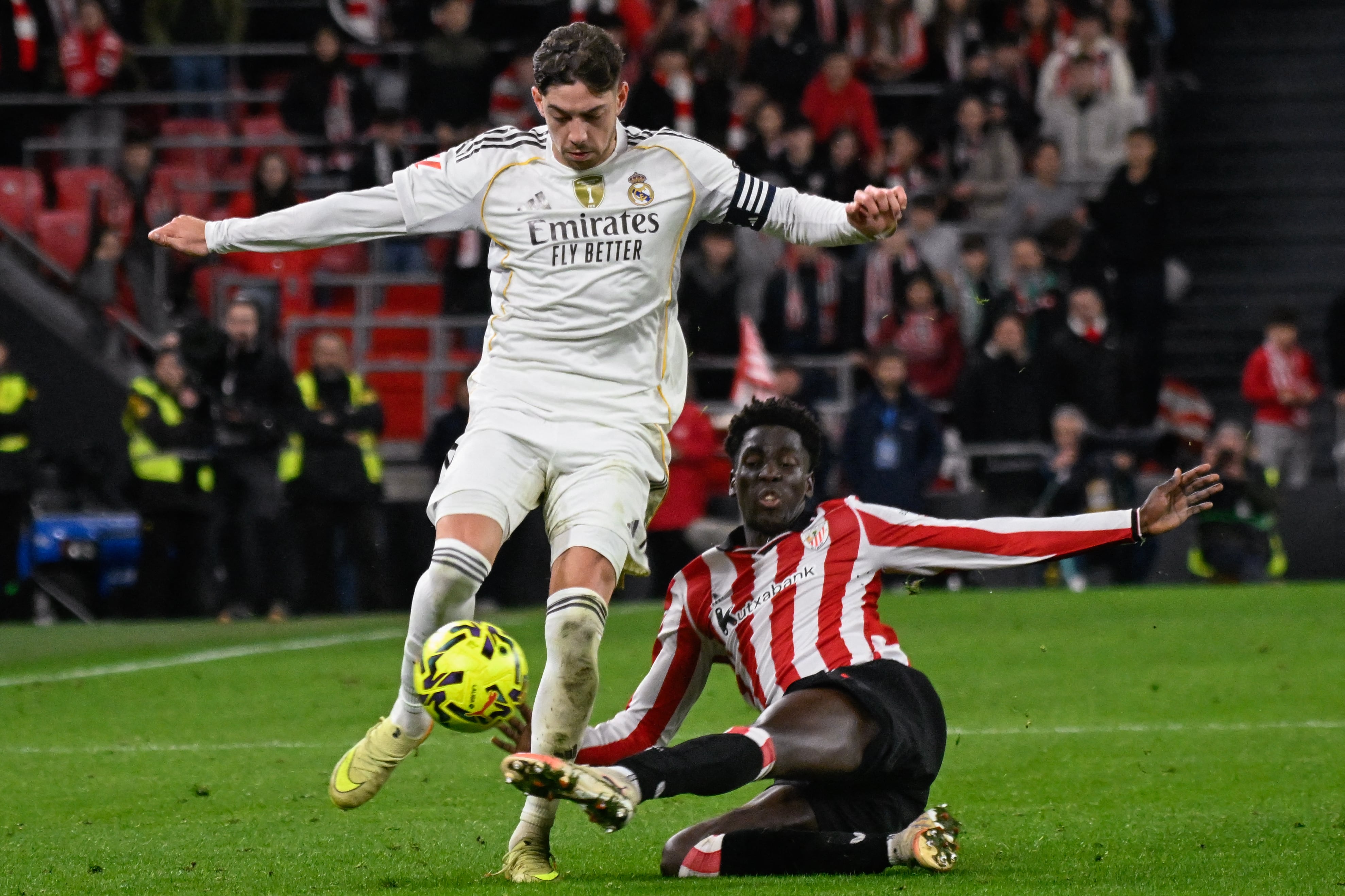 El mediocampista uruguayo del Real Madrid Federico Valverde disputa el balón con el español Adama Boiro, del Athletic de Bilbao, durante el compromiso en San Mamés por la Liga Española.