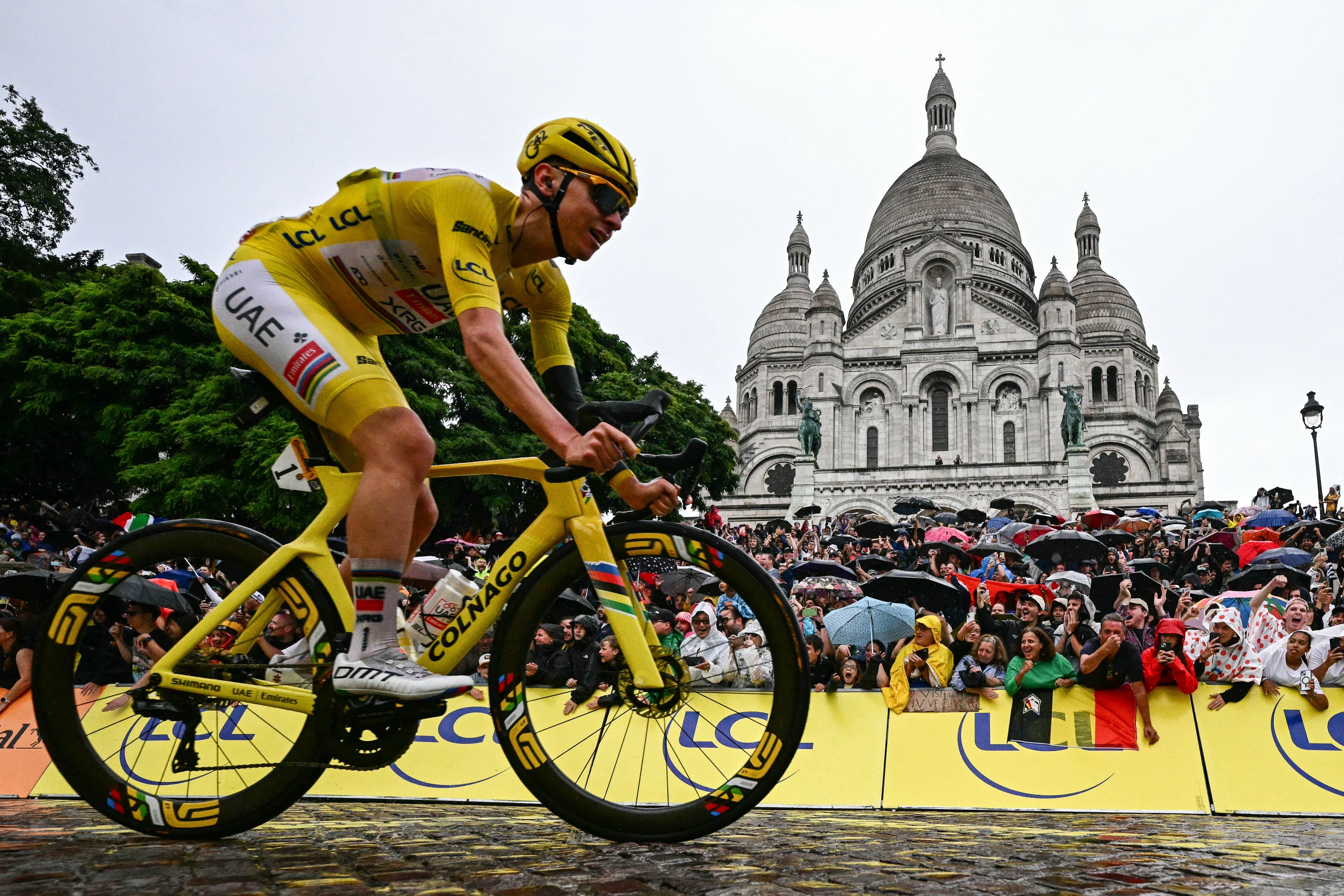 El cuatro veces campeón del Tour de Francia, Tadej Pogacar, pasa frente a la Basílica del Sagrado Corazón en el barrio parisino de Montmartre, durante la última etapa.