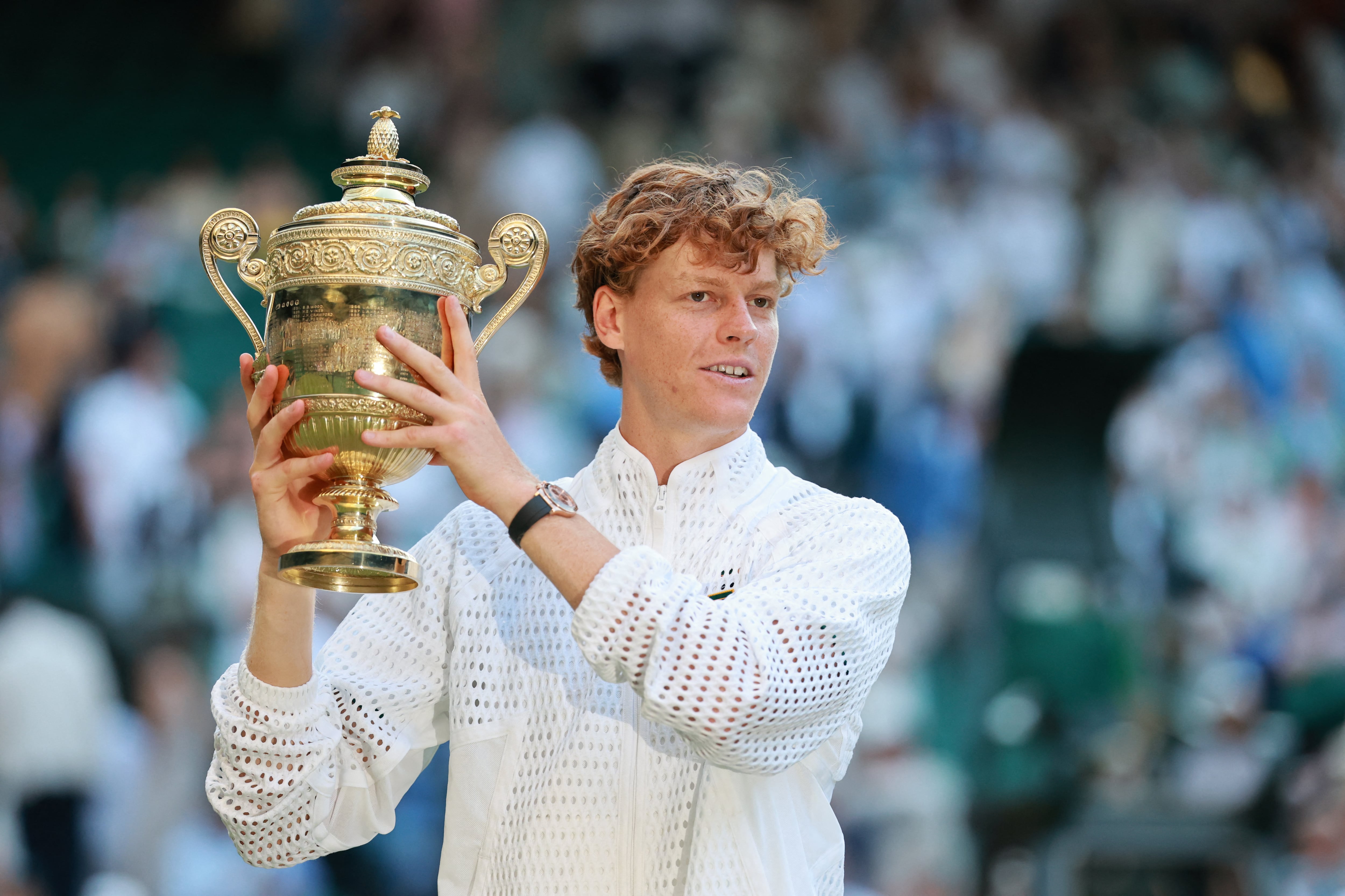 Jannik Sinner, de Italia, sostiene el trofeo del Abierto de Wimbledon de Inglaterra tras vencer a Alexander Zverev de Alemania en la final del más prestigioso torneo de tenis.
