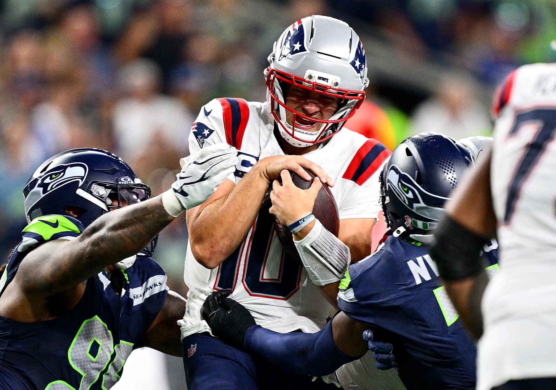 Drake Maye, de los New England Patriots, es derribado por Leonard Williams, de los Seattle Seahawks, en el partido inaugural en el Lumen Field de Seattle, que también fue sede del pasado Mundial 2026.