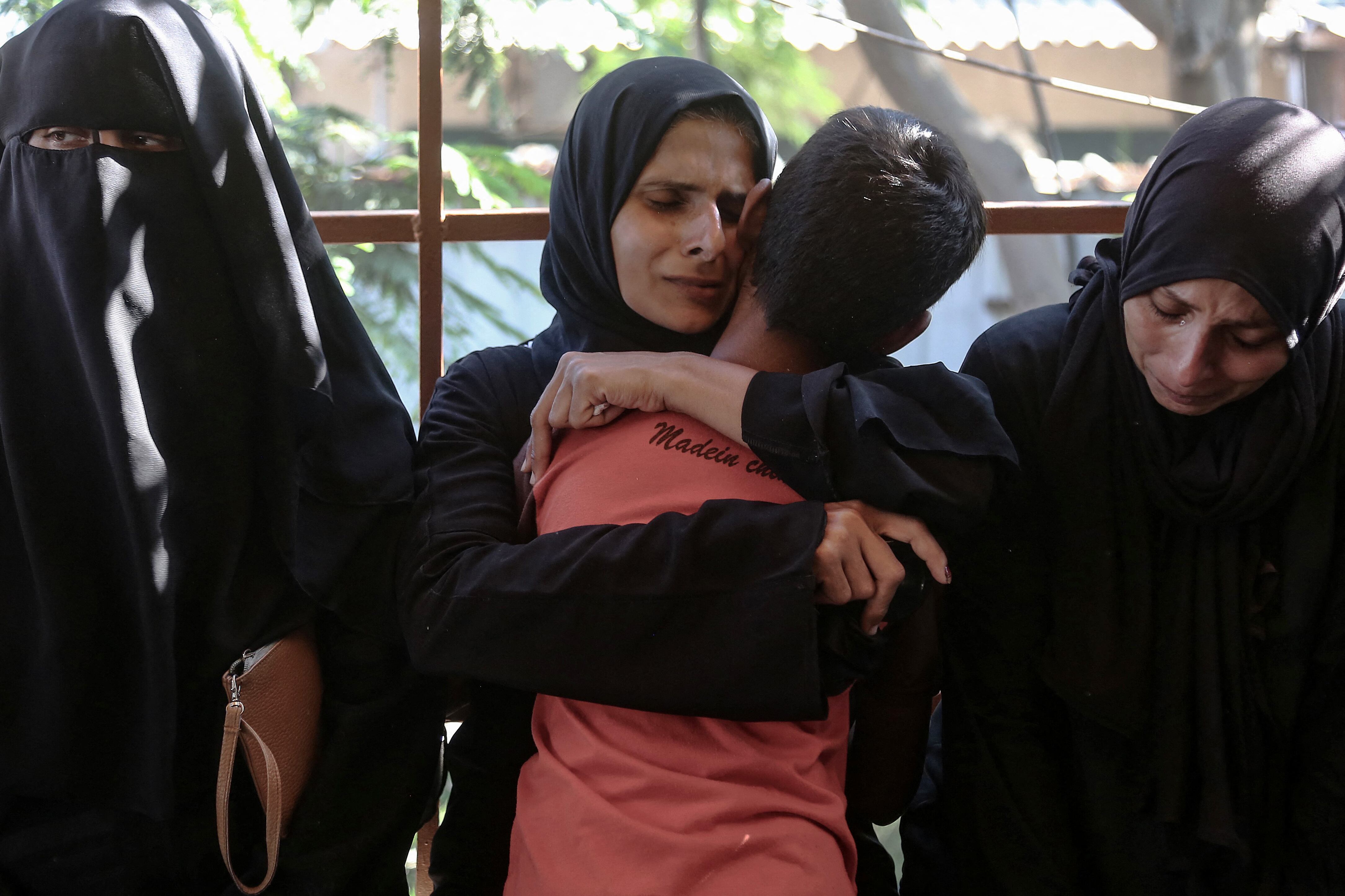 Una madre abraza a su hijo después de identificar el cuerpo de un miembro de su familia entre los palestinos asesinados por disparos de Israel en el campo de refugiados de al-Mawasi, en Gaza.