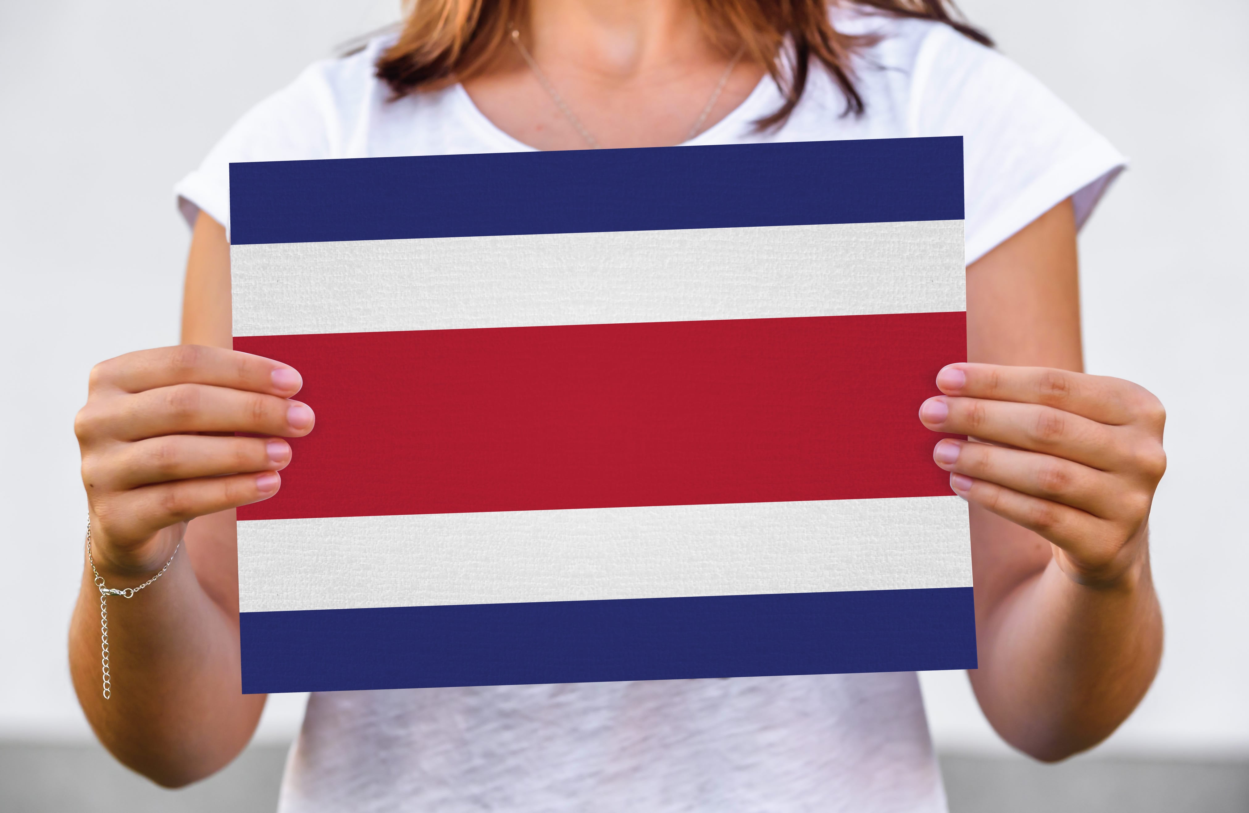 Mujer cuyo rostro no se ve sostiene bandera de Costa Rica