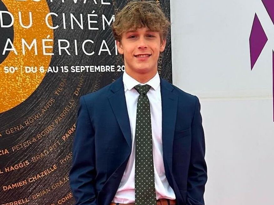 Foto del actor estadounidense Hudson Meek vestido con traje azul, camisa blanca y corbata negra con puntos blancos