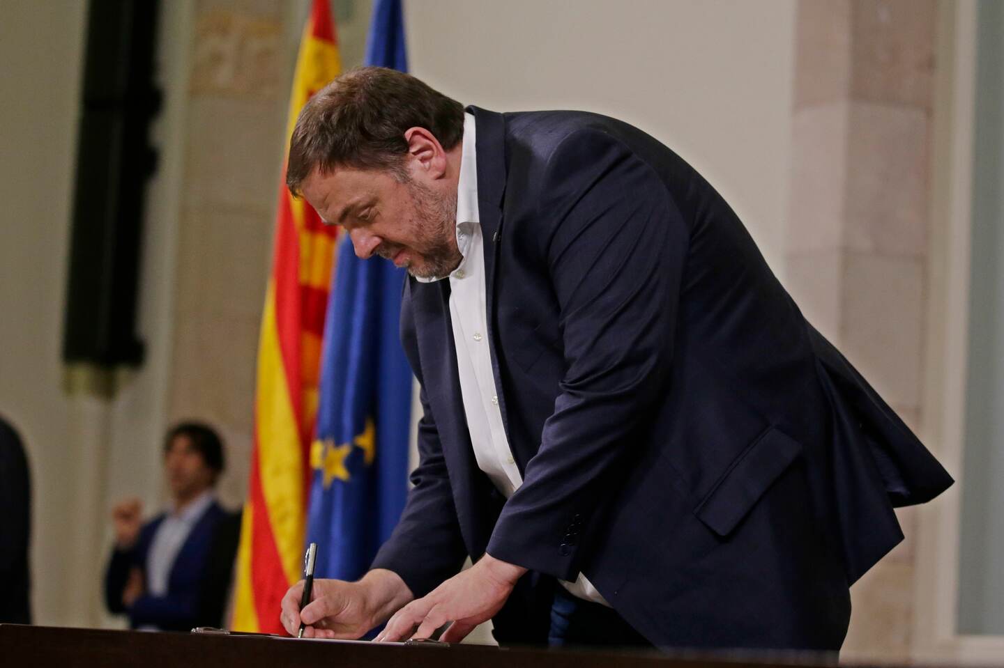 FILE - In this Oct. 10, 2017 file photo, the then deputy president of the Catalan regional government Oriol Junqueras signs an independence declaration document after a parliamentary session in Barcelona, Spain. Spanish prosecutors on Friday Nov. 2, 2018 have called for former Catalan Vice President Oriol Junqueras to be imprisoned for 25 years on charges of rebellion and misuse of public funds, the highest prison term being sought for separatist leaders who pushed for Catalan independence last year. (AP Photo/Manu Fernandez, File)