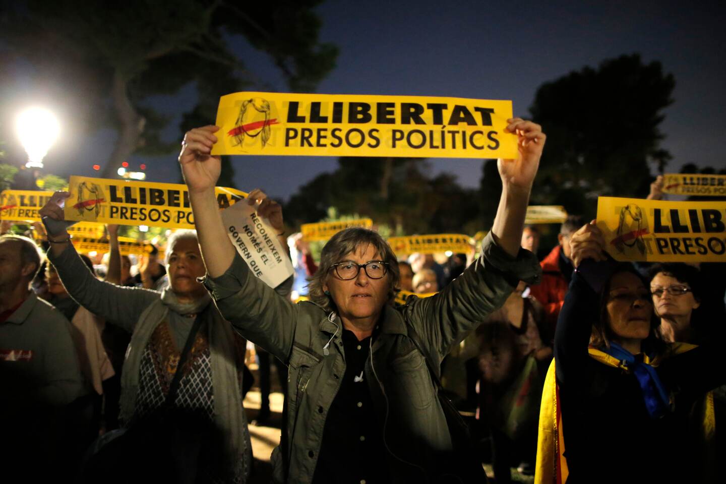 Demonstrators gather outside the Catalonian Parliament to protest against the decision of a judge to jail ex-members of the Catalan government, in Barcelona, Spain, Thursday, Nov. 2, 2017. A Spanish judge has ordered nine ex-members of the government in Catalonia jailed while they are investigated on possible charges of sedition, rebellion and embezzlement. Banners translate as 'Freedom for Political Prisoners'. (AP Photo/Manu Fernandez)