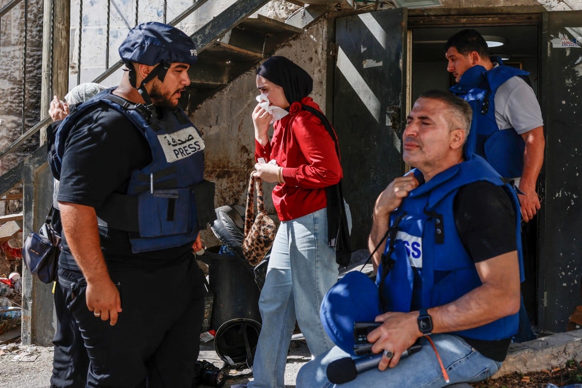 Periodistas y un civil reaccionan después de inhalar gases lacrimógenos durante una incursión de las fuerzas israelíes en el Centro de Formación Profesional de la UNRWA, ubicado entre el barrio de Kafr Aqab y el campamento de refugiados de Qalandia, al sur de la ciudad cisjordana de Ramala, el 25 de agosto de 2026.