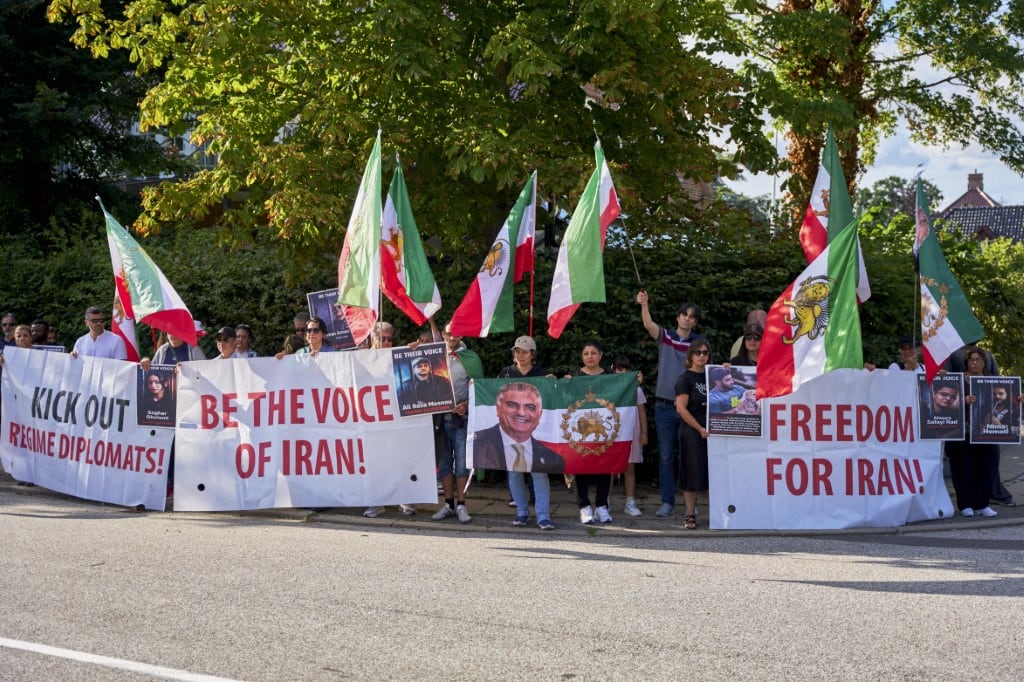Manifestantes sostienen pancartas y banderas iraníes anteriores a la revolución durante una protesta frente a la Embajada de Irán en Copenhague, Dinamarca, el 28 de julio de 2026.
