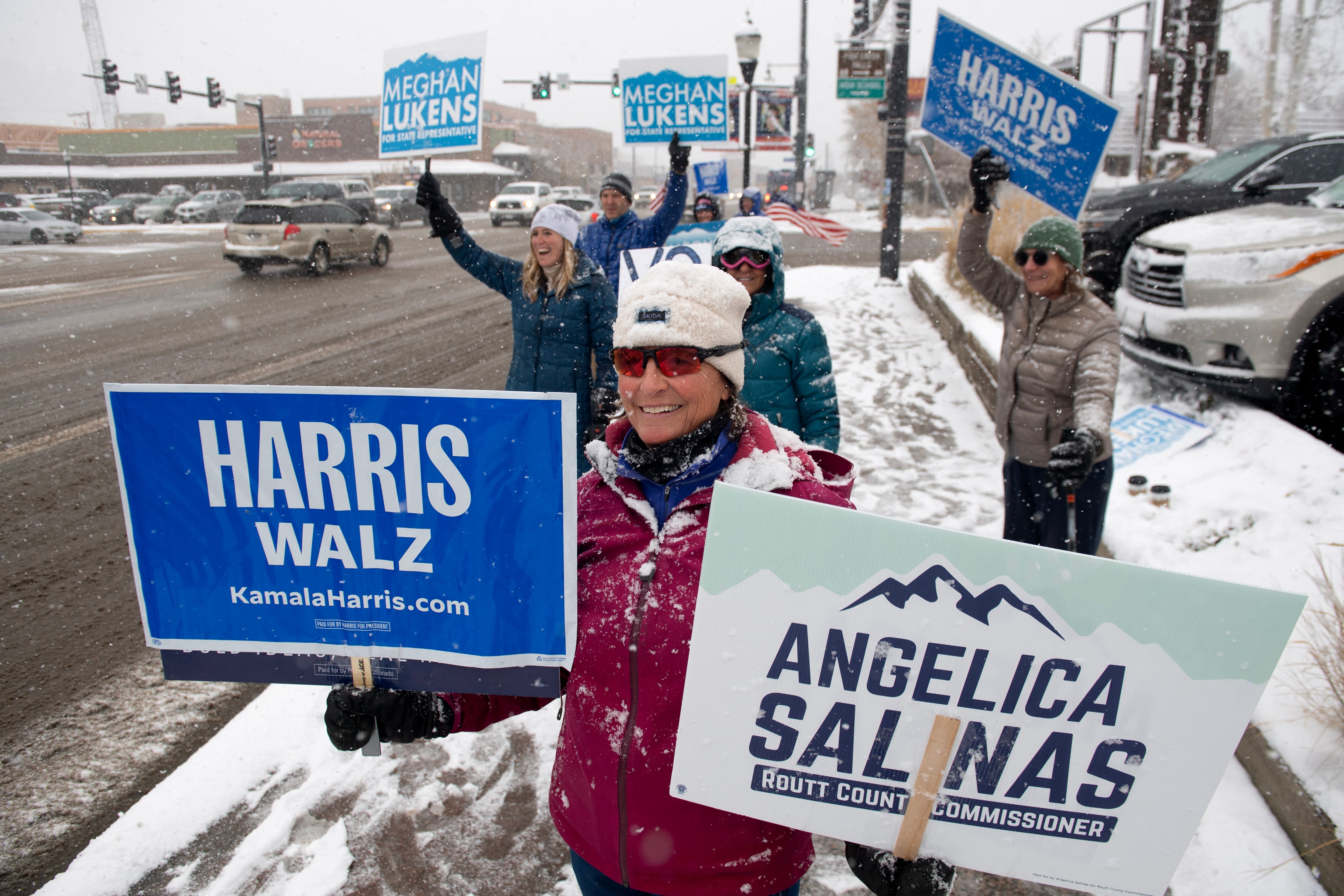 Megan Richard (centro), de Steamboat Springs, Colorado, agita carteles en apoyo a la vicepresidenta estadounidense y candidata presidencial demócrata Kamala Harris entre el tráfico en Steamboat Springs, Colorado, el día de las elecciones.