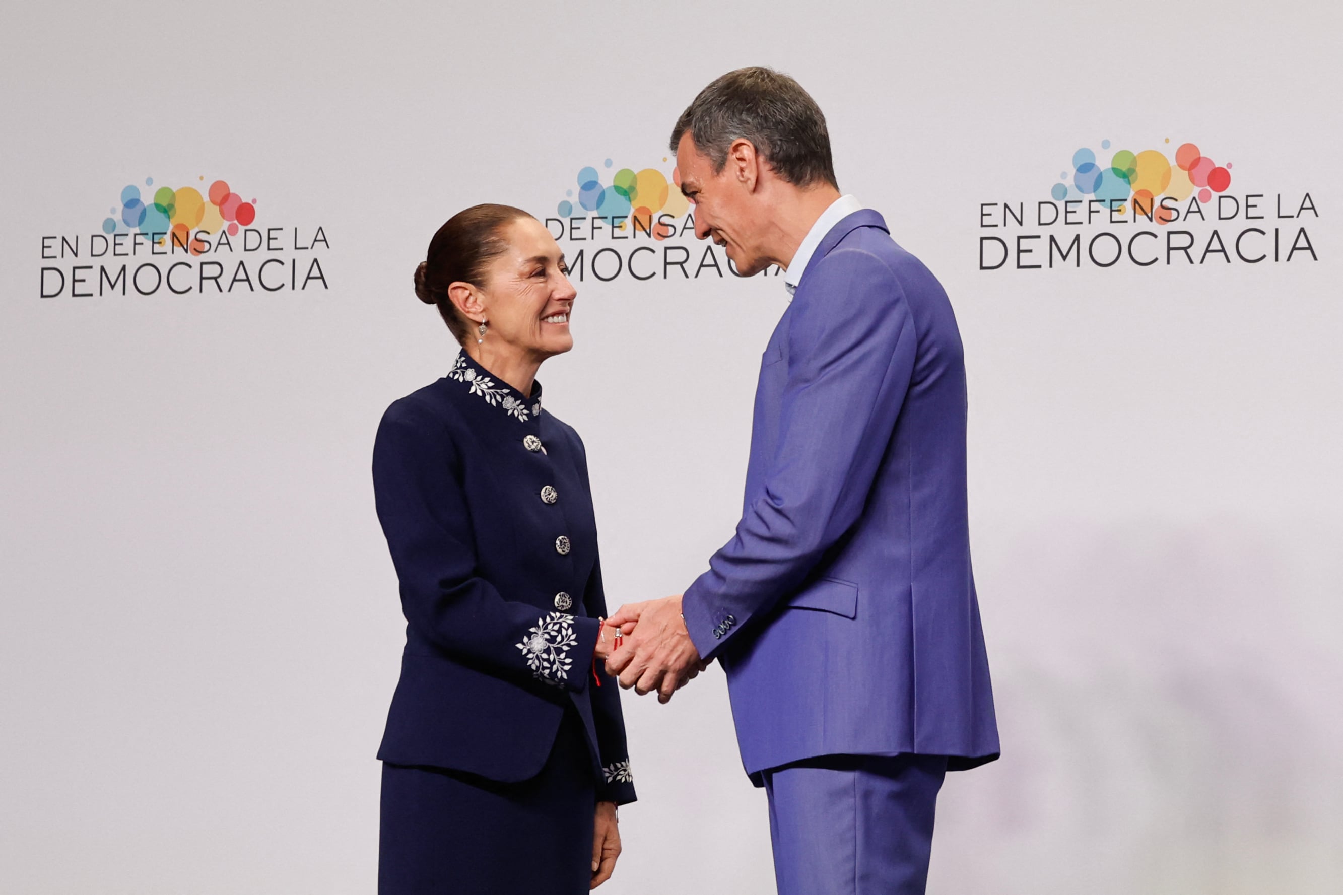La presidenta de México, Claudia Sheinbaum (izquierda), saluda al presidente del Gobierno de España, Pedro Sánchez, en el "Encuentro en Defensa de la Democracia", una reunión de líderes de izquierda que busca movilizarse contra la amenaza a la democracia por parte de la extrema derecha en Barcelona, el 18 de abril de 2026. El encuentro se produce en un contexto en el que las instituciones y los valores democráticos se enfrentan a crecientes amenazas en todo el mundo por parte de fuerzas autoritarias y de extrema derecha en la era del presidente estadounidense Donald Trump. Muchos de los participantes tomarán parte en la primera edición de la llamada "Movilización Progresista Global", que se celebrará en el mismo lugar.