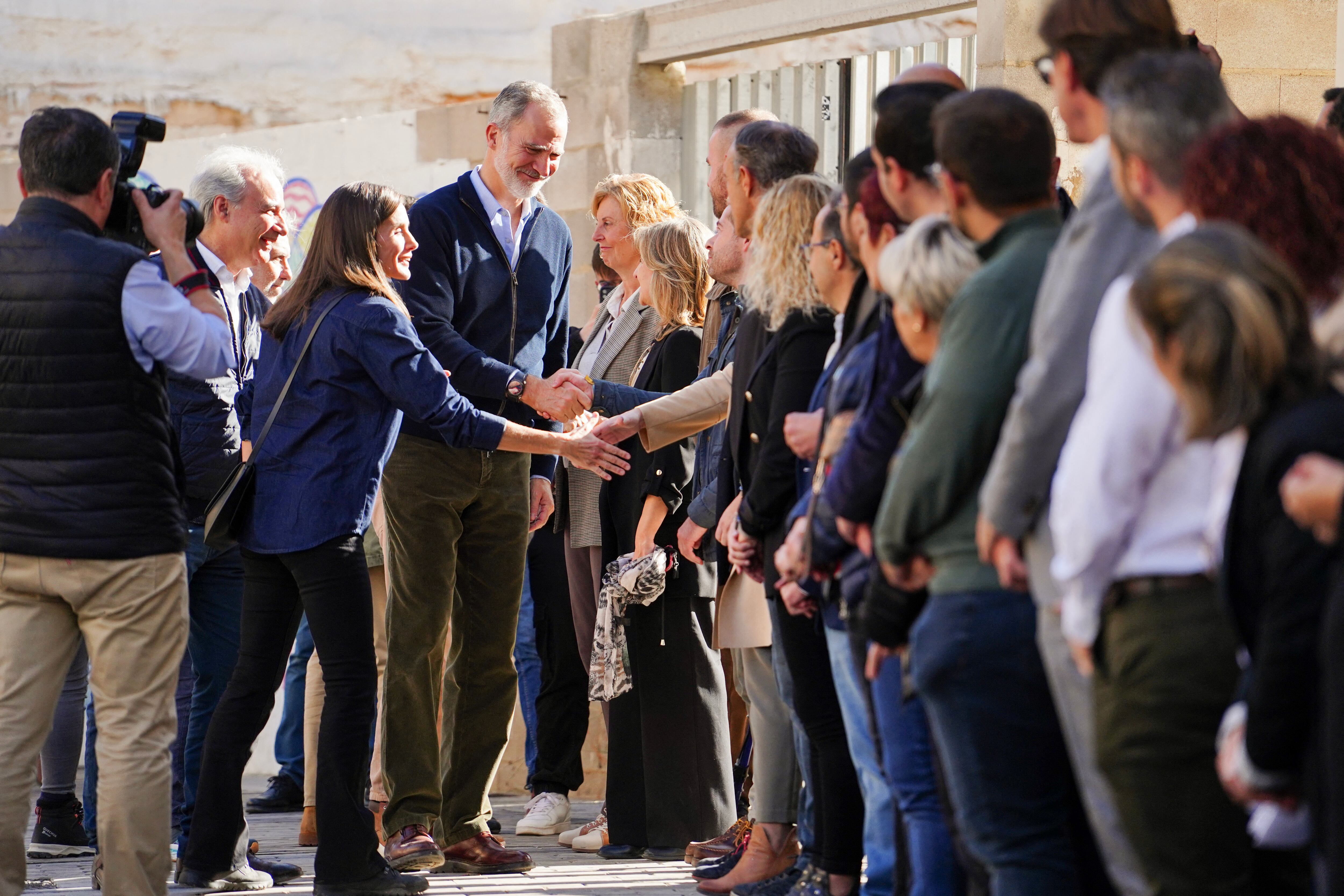 El rey Felipe VI y la reina Letizia saludan a los residentes durante su visita a la ciudad de Utiel, en la región de Valencia, este de España, afectada por las catastróficas inundaciones.
