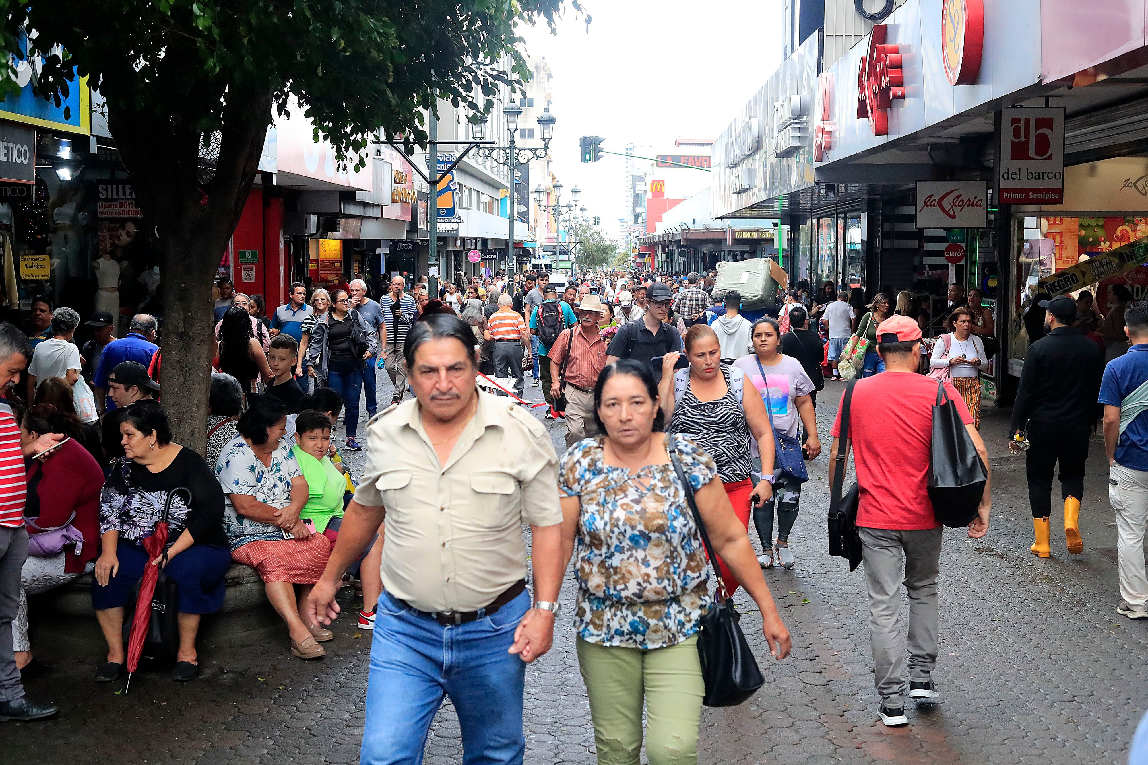 Fotografía de una calle llena de peatones en San José, Costa Rica, destacando la actividad económica y social en un día laboral.