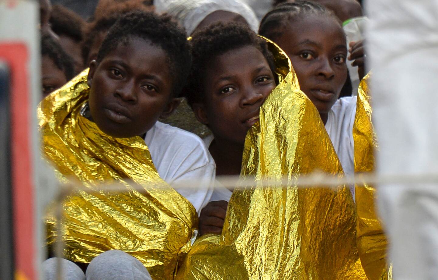 Dos migrantes se protegen con mantas térmicas luego de ser rescatados de un naufragio en las cosas de Libia.