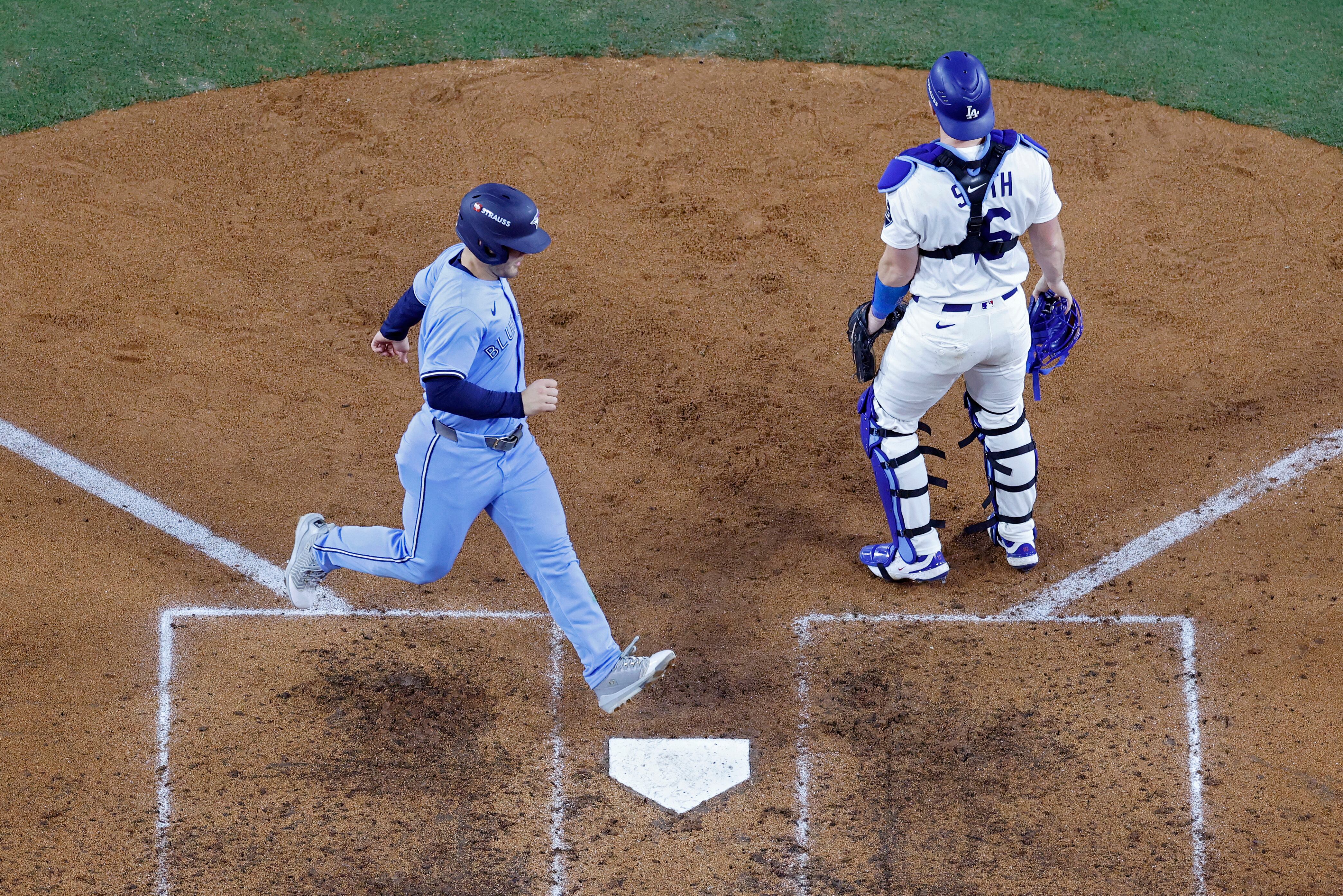 Daulton Varsho de los Azulejos de Toronto anota una carrera sin que el catcher de los Dodgers, Will Smith, pueda hacer nada en este cuarto juego de la Serie Mundial.