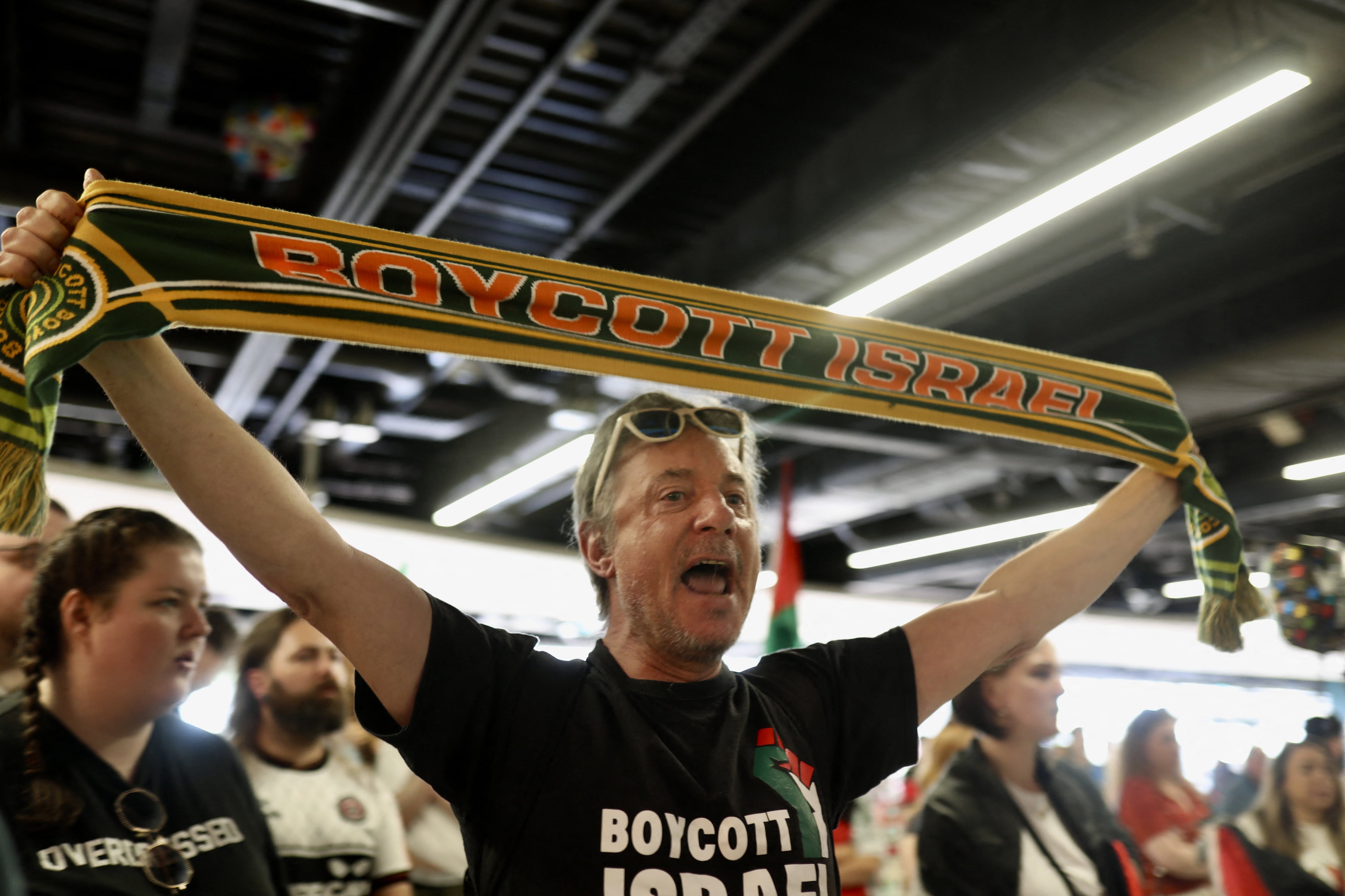 Este hombre muestra un llamado al boicot de Israel, al recibir a un grupo de activistas irlandeses tras ser deportados desde Israel en mayo pasado.