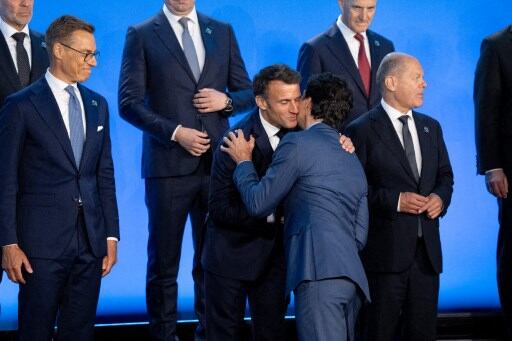 El presidente francés Emmanuel Macron saluda al primer ministro de Canadá Justin Trudeau en el escenario antes de una fotografía grupal durante la cumbre de la OTAN el 10 de julio del 2024 en Washington, D. C.