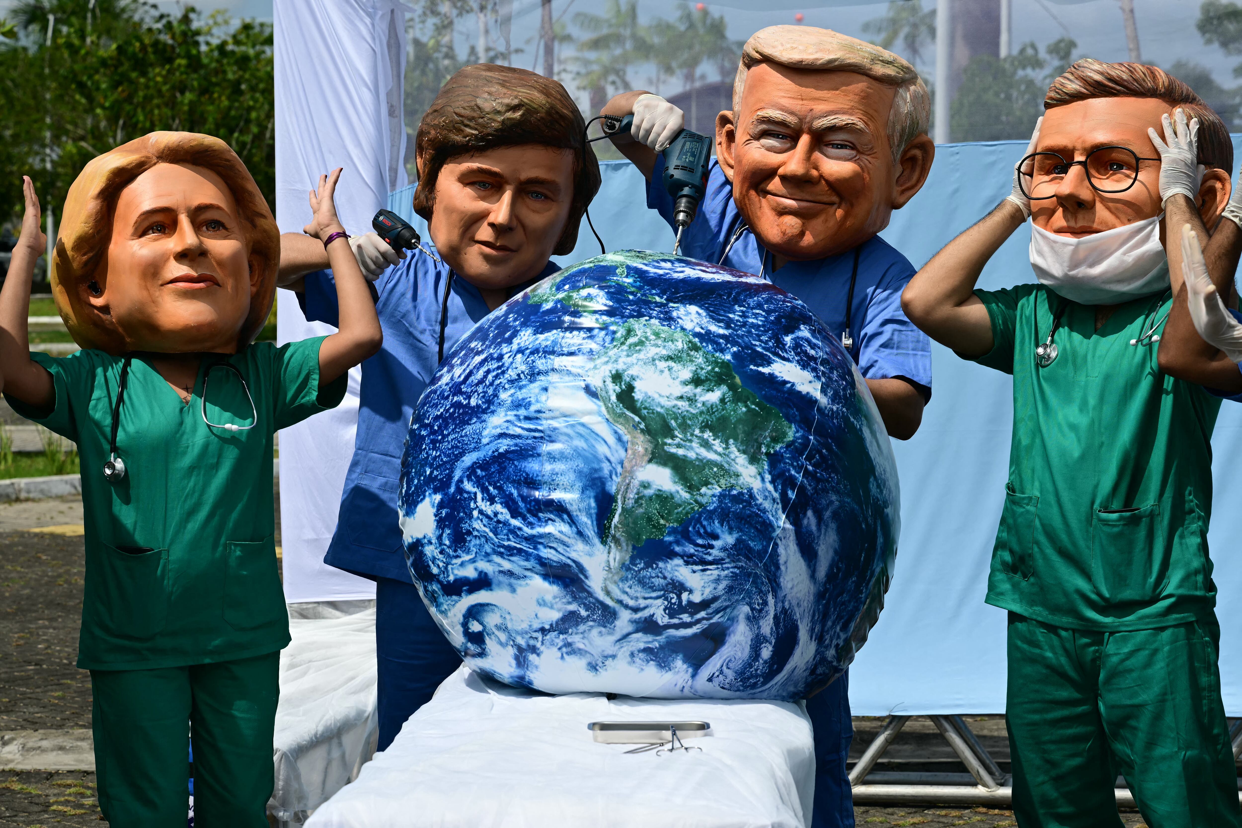 Activistas de Oxfam, con máscaras de gran tamaño que representan (de izquierda a derecha) a la Presidenta de la Comisión Europea Ursula Von der Leyen, al Presidente de Argentina Javier Milei, al Presidente de Estados Unidos Donald Trump y al Primer Ministro de Gran Bretaña Keir Starmer