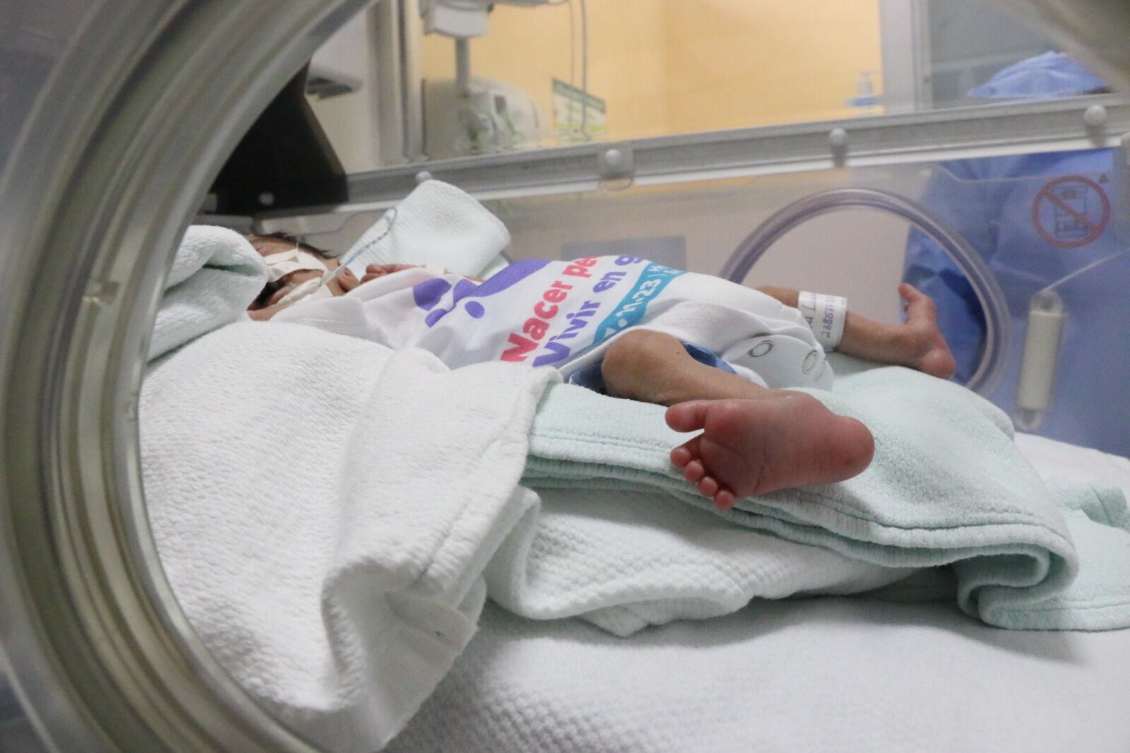 En la imagen se observa a un bebé prematuro en una incubadora de un centro médico público.