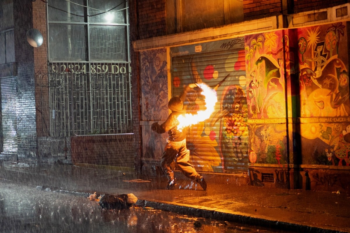 Un manifestante lanza una bomba molotov durante enfrentamientos con la Policía tras una protesta contra el presidente colombiano, Abelardo de la Espriella, en Bogotá, el 14 de octubre de 2026.