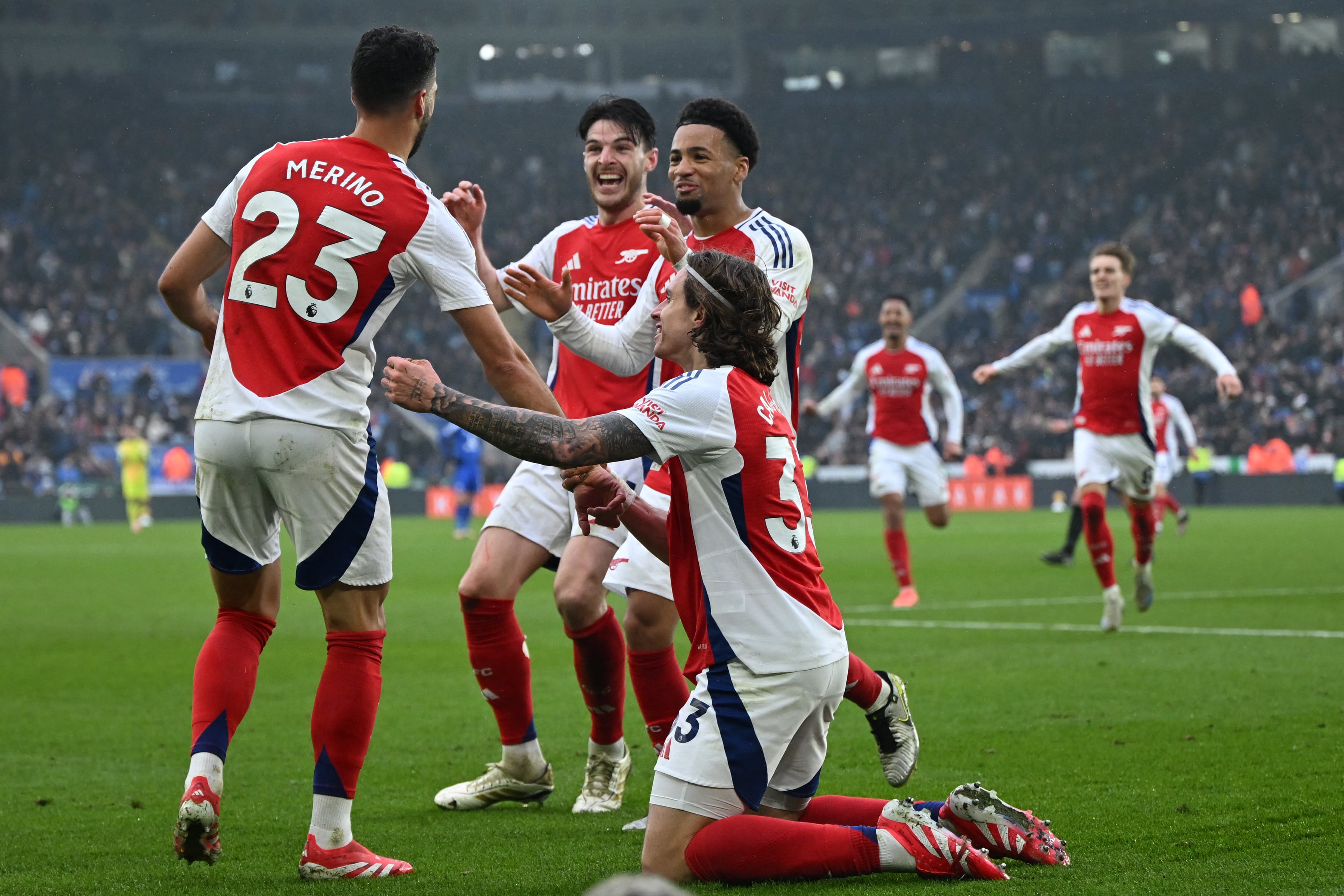 Arsenal's Spanish midfielder #23 Mikel Merino (L) celebrates with teammates after scoring their second goal during the English Premier League football match between Leicester City and Arsenal at King Power Stadium in Leicester, central England on February 15, 2025. (Photo by JUSTIN TALLIS / AFP) / RESTRICTED TO EDITORIAL USE. No use with unauthorized audio, video, data, fixture lists, club/league logos or 'live' services. Online in-match use limited to 120 images. An additional 40 images may be used in extra time. No video emulation. Social media in-match use limited to 120 images. An additional 40 images may be used in extra time. No use in betting publications, games or single club/league/player publications. /