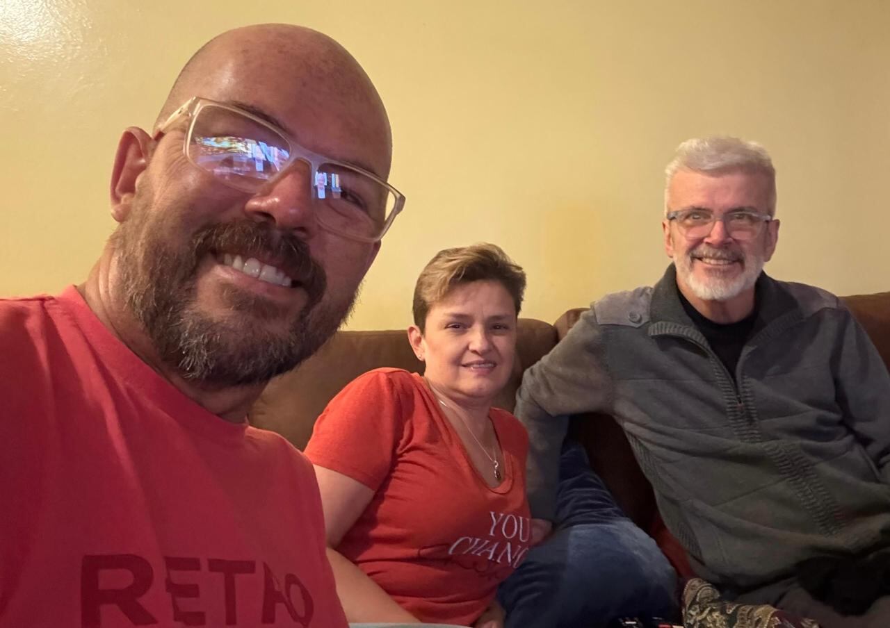 Tres personas en una fotografía, una mujer en medio de dos hombres.