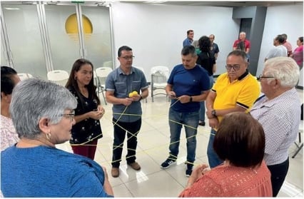 Un grupo de personas realizando un juego con un ovillo de lana.