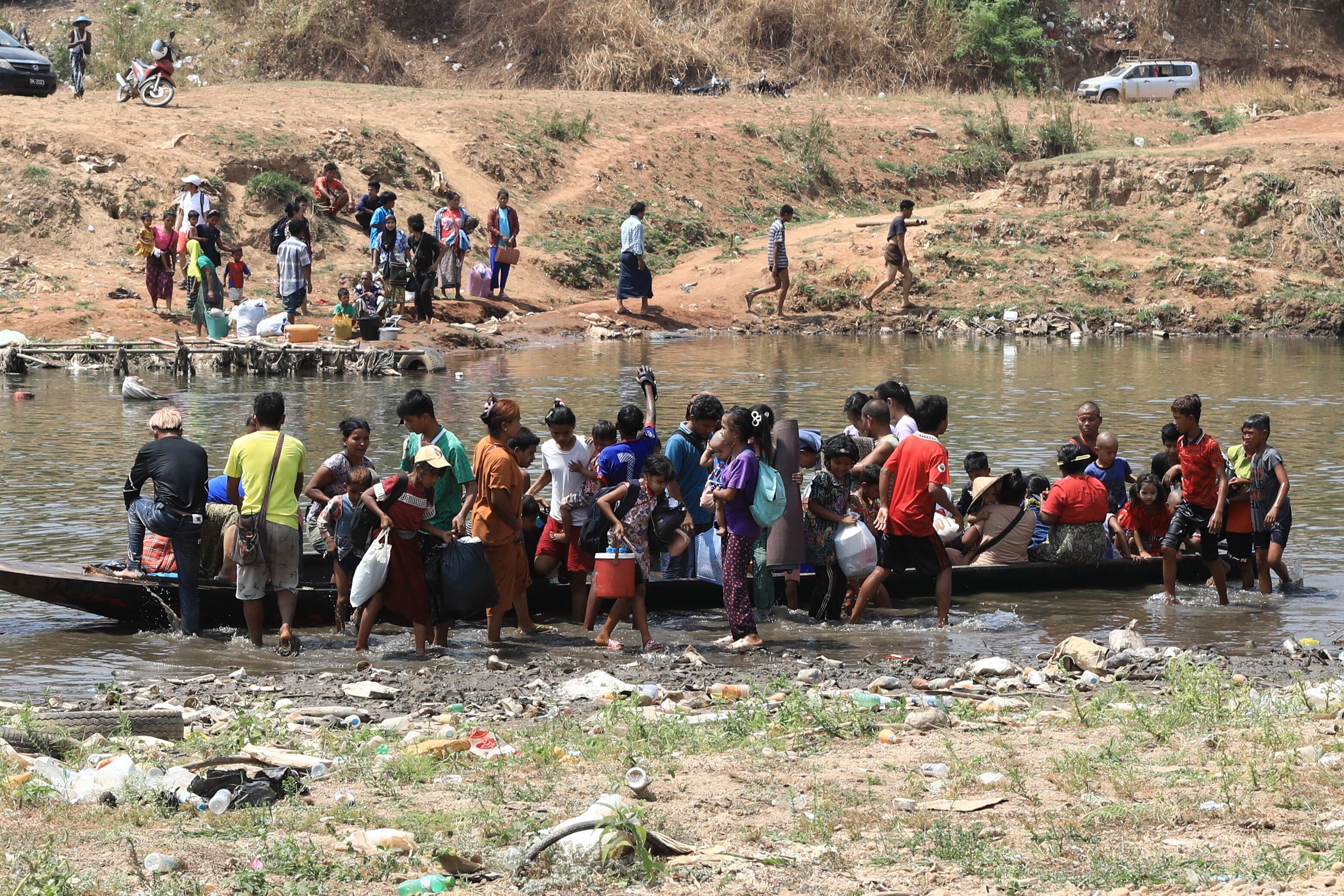 Refugiados de Myanmar, devastados por la guerra, cruzan la frontera hacia Tailandia debido a los intensos combates entre la oposición y el gobierno militar en Myawaddy. Foto de abril 2024