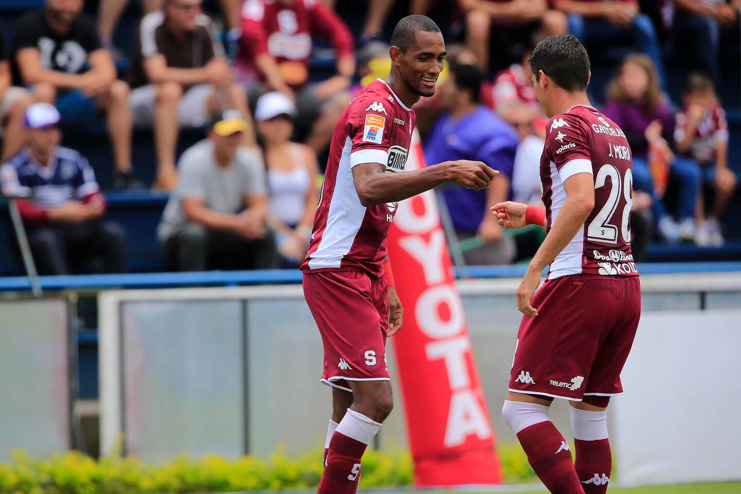 Jerry Bengtson (izquierda) celebra su anotación ante Carmelita junto con Joseph Mora (derecha).