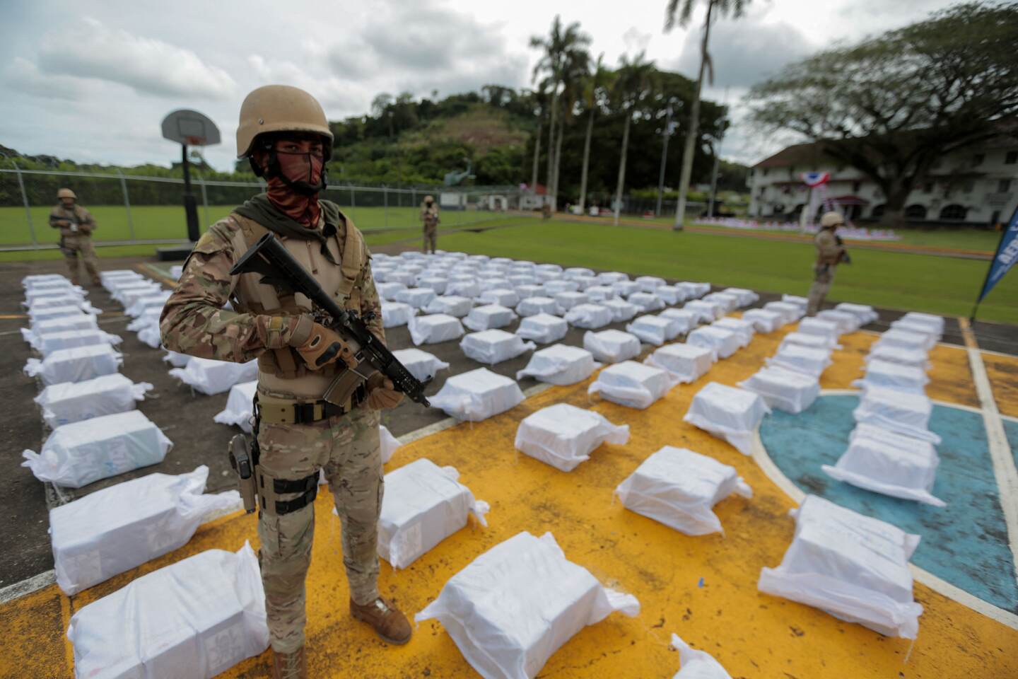 (FILES) In this file photo taken on October 30, 2021 members of the National Aeronaval Service (SENAN) guard drug packages as they are displayed during a press conference at a military base in Panama City. - Central American countries seized around 250 tons of drug in 2021, a record figure originated by the increase in the production of cocaine and the new strategies of drug traffickers to transport it to the US and Europe. (Photo by Rogelio FIGUEROA / AFP)
