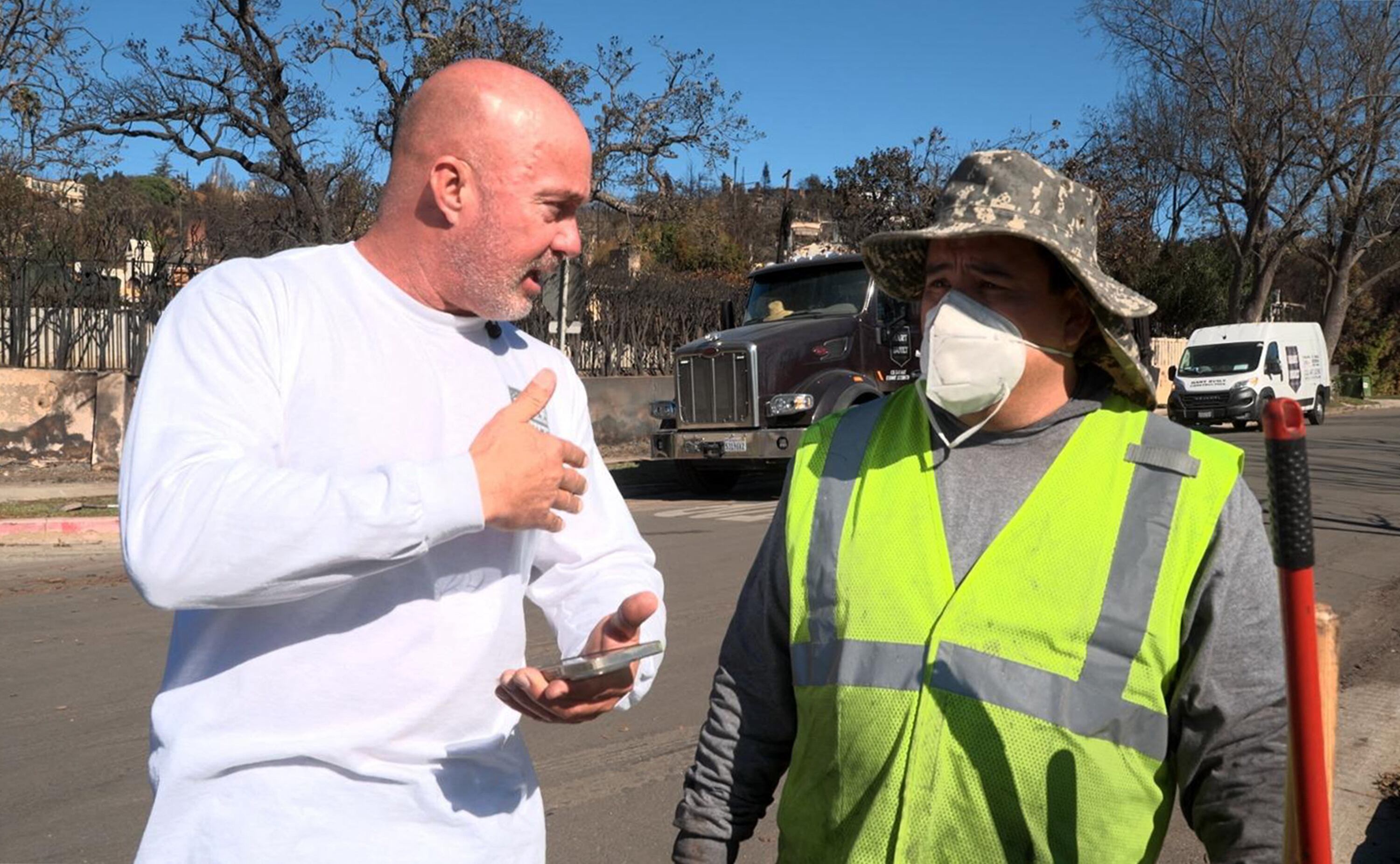 Chuck Hart (izq.), de Hart Built Construction, habla con un empleado mientras limpian las calles del barrio de Pacific Palisades en Los Ángeles, California. Hart y su equipo trabajan como voluntarios sin pago ni apoyo oficial.