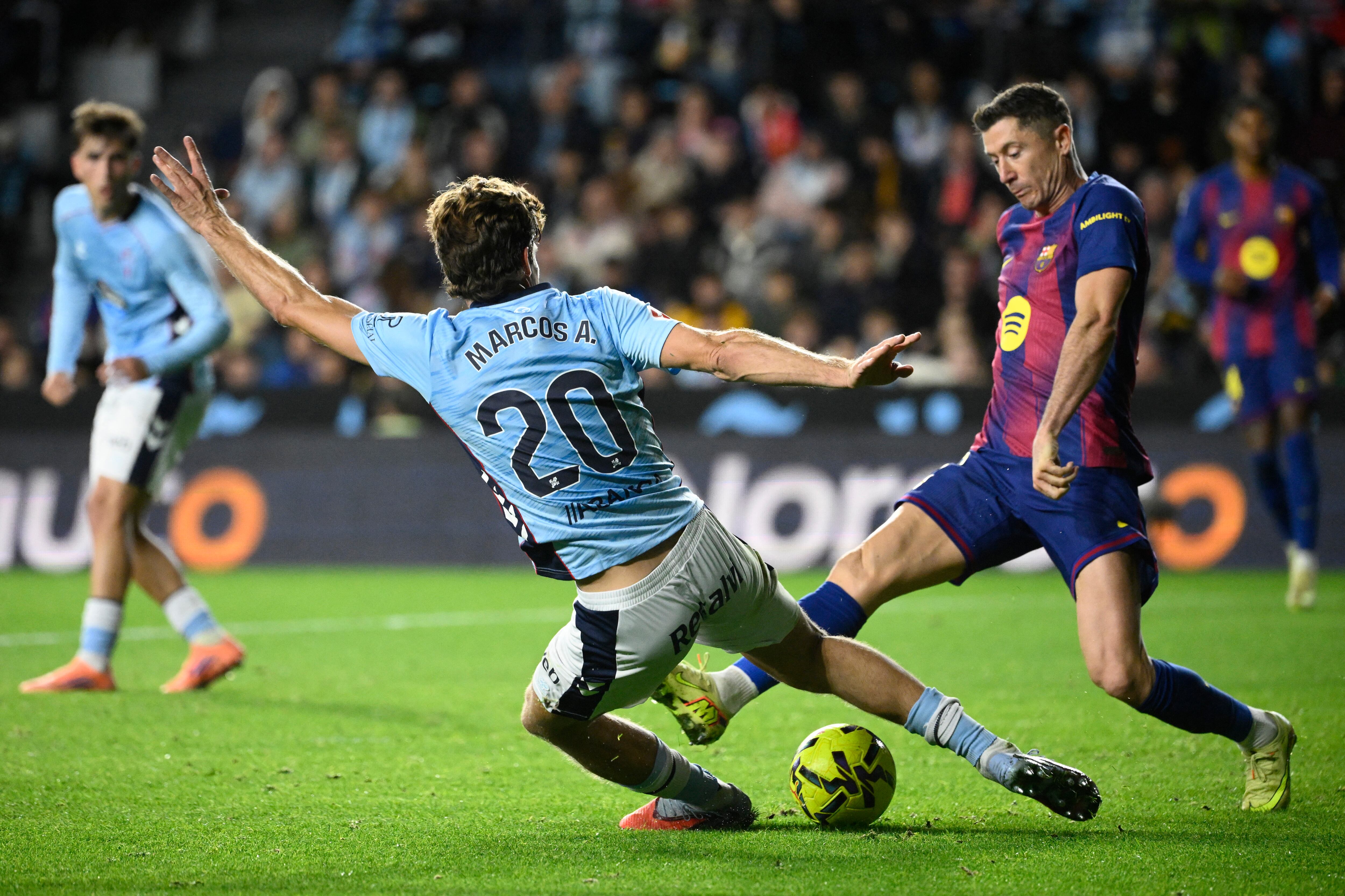 El defensor del Celta Marcos Alonso Mendoza disputa el balón con el delantero del Barcelona Robert Lewandowski durante el partido en Balaídos por la Liga Española.