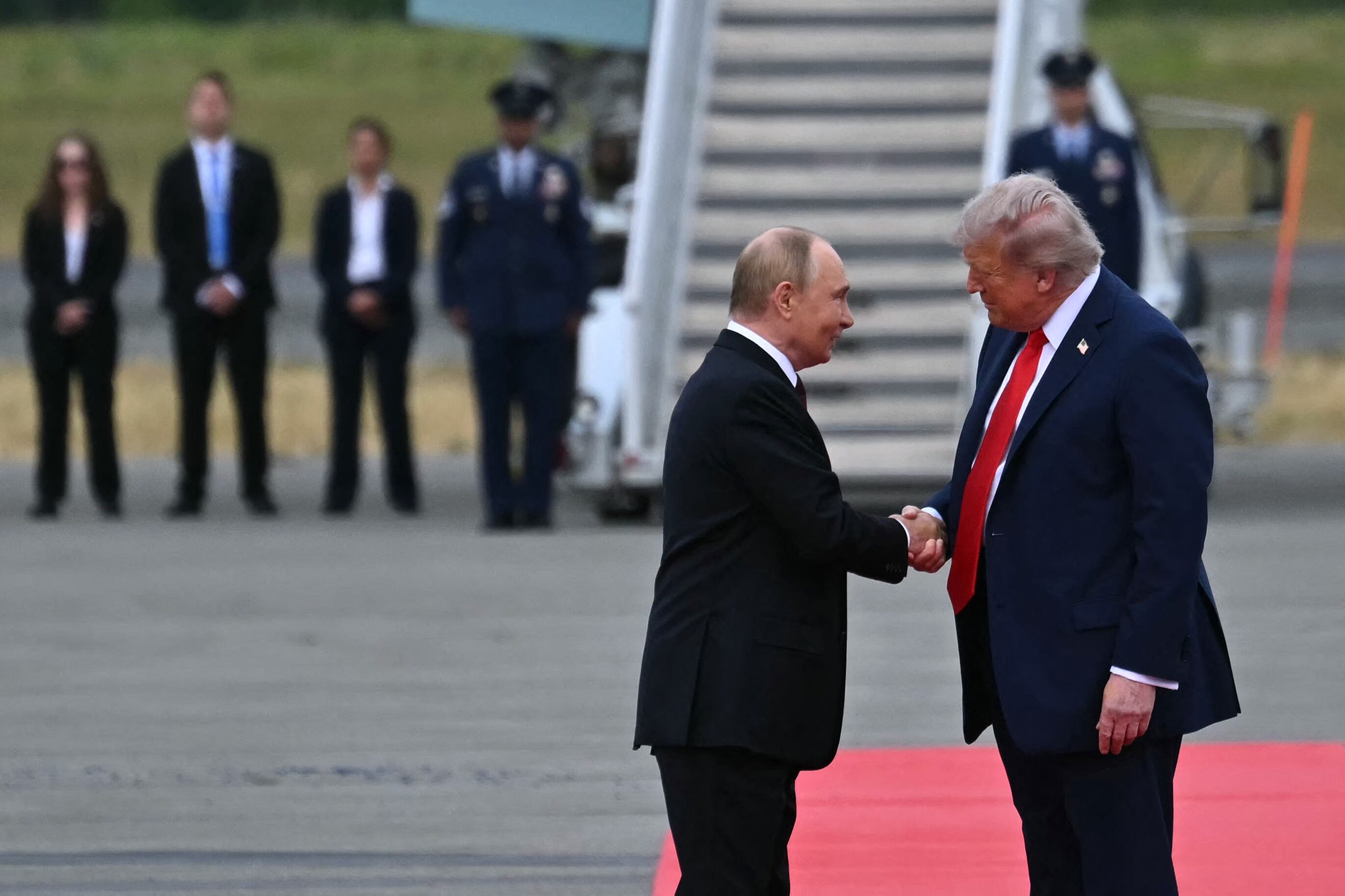 Donald Trump (der.) estrecha la mano del presidente ruso Vladimir Putin en la pista tras su llegada a la Base Conjunta Elmendorf-Richardson en Anchorage, Alaska,