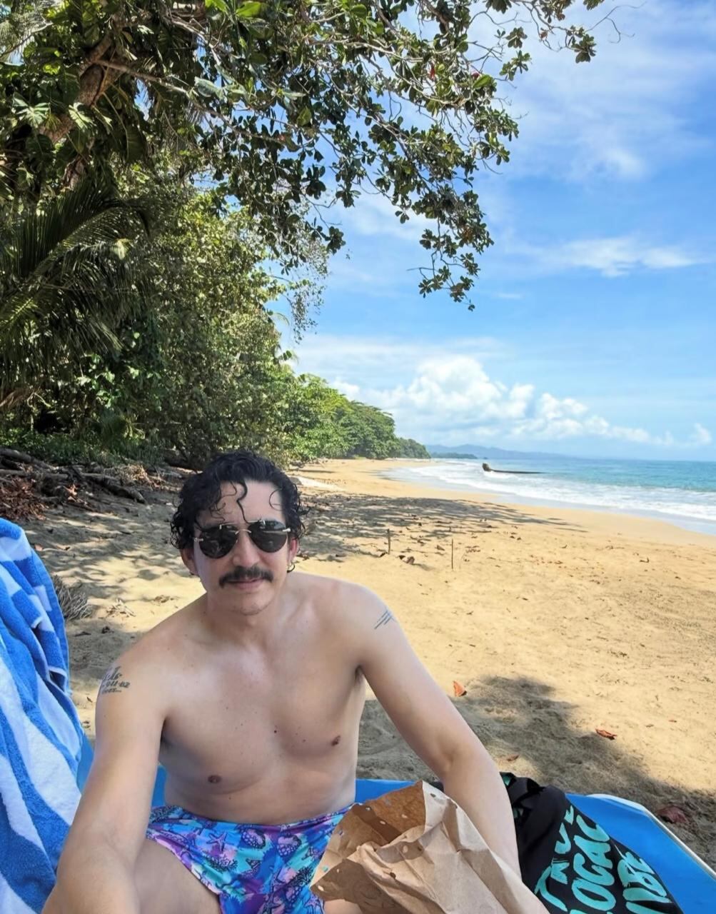 El actor estadounidense Gabriel Luna en la playa Punta Uva de Puerto Viejo, Limón, Costa Rica, con una bebida de mate.