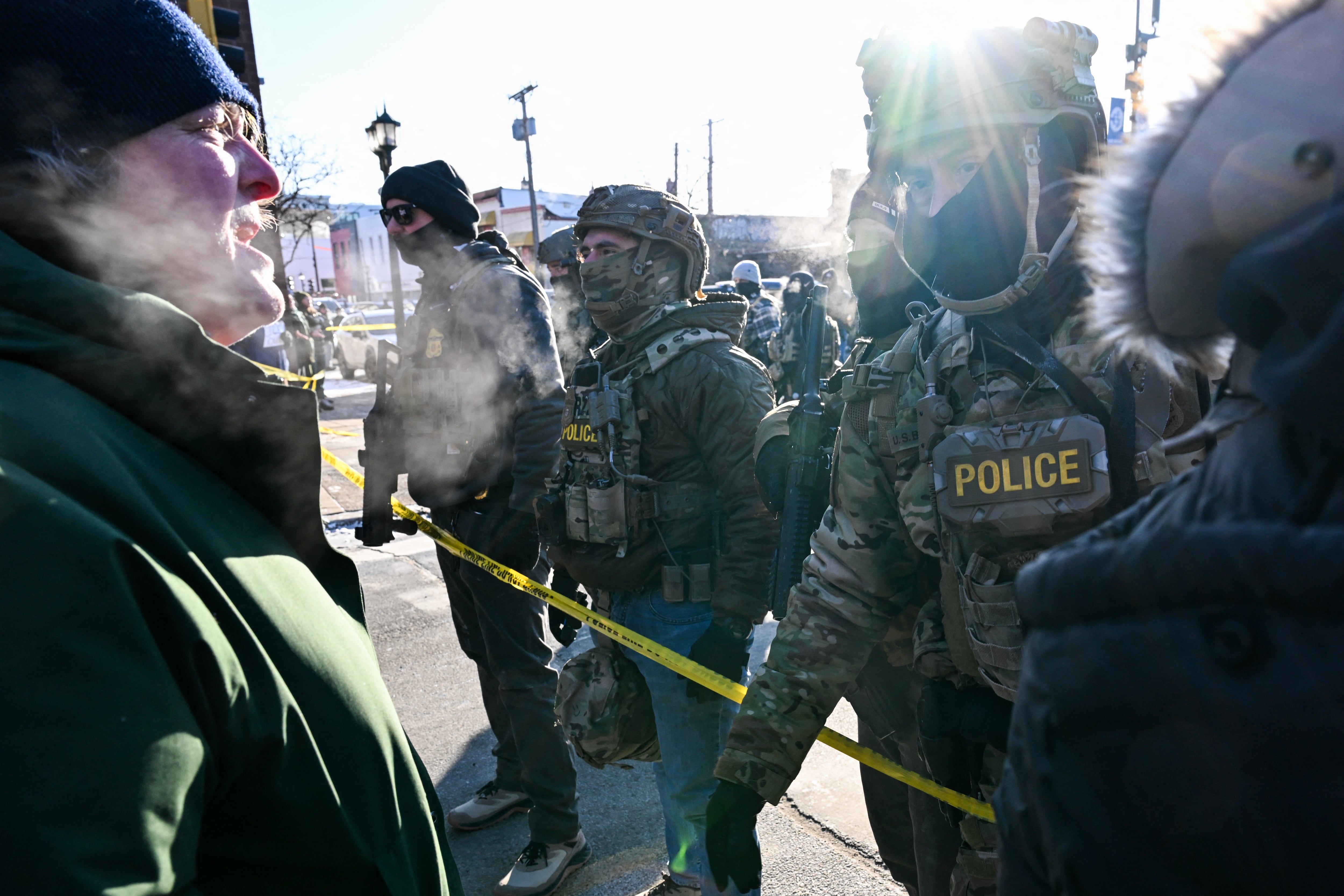 Un hombre habla con agentes federales mientras los manifestantes se reúnen cerca del lugar donde, según las autoridades estatales y locales, un hombre fue baleado por agentes federales esa misma mañana en Minneapolis, Minnesota. Fotografía: