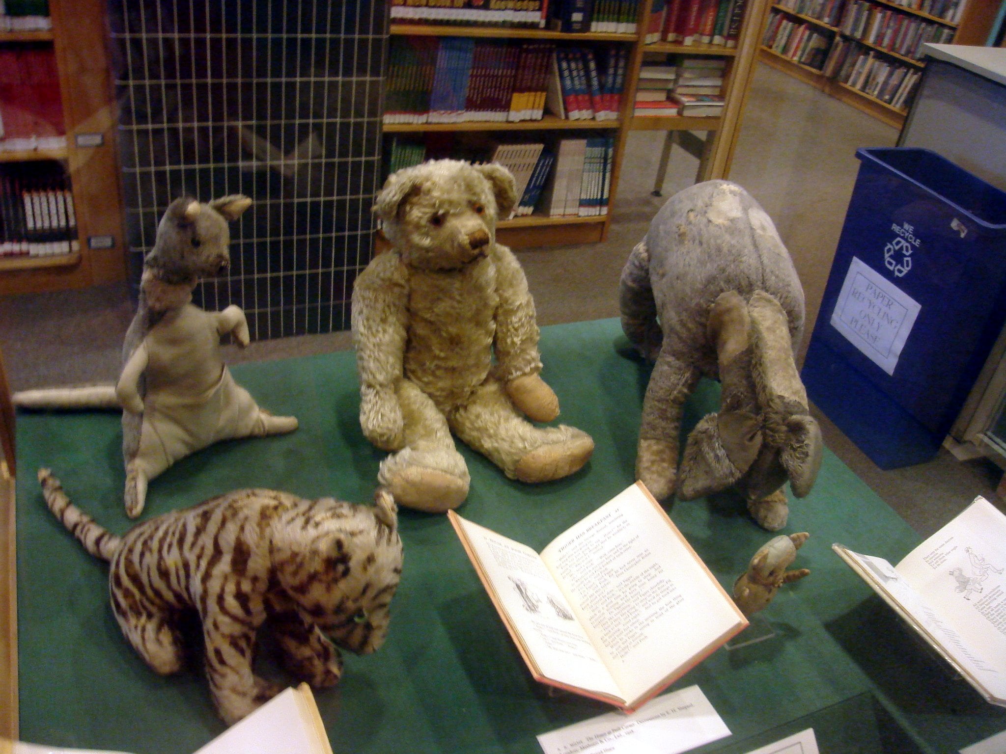 Los peluches originales de Winnie-the-Pooh en el Donnell Library Centre de la ciudad de Nueva York. En sentido de las agujas del reloj desde abajo a la izquierda: Tigger, Kanga, Edward Bear «Winnie-the-Pooh», Eeyore y Piglet. Roo también formaba parte del grupo, pero se perdió en la década de 1930 en un huerto de manzanas en algún lugar de Sussex. Búho y Conejo no tenían versiones originales en peluche.
