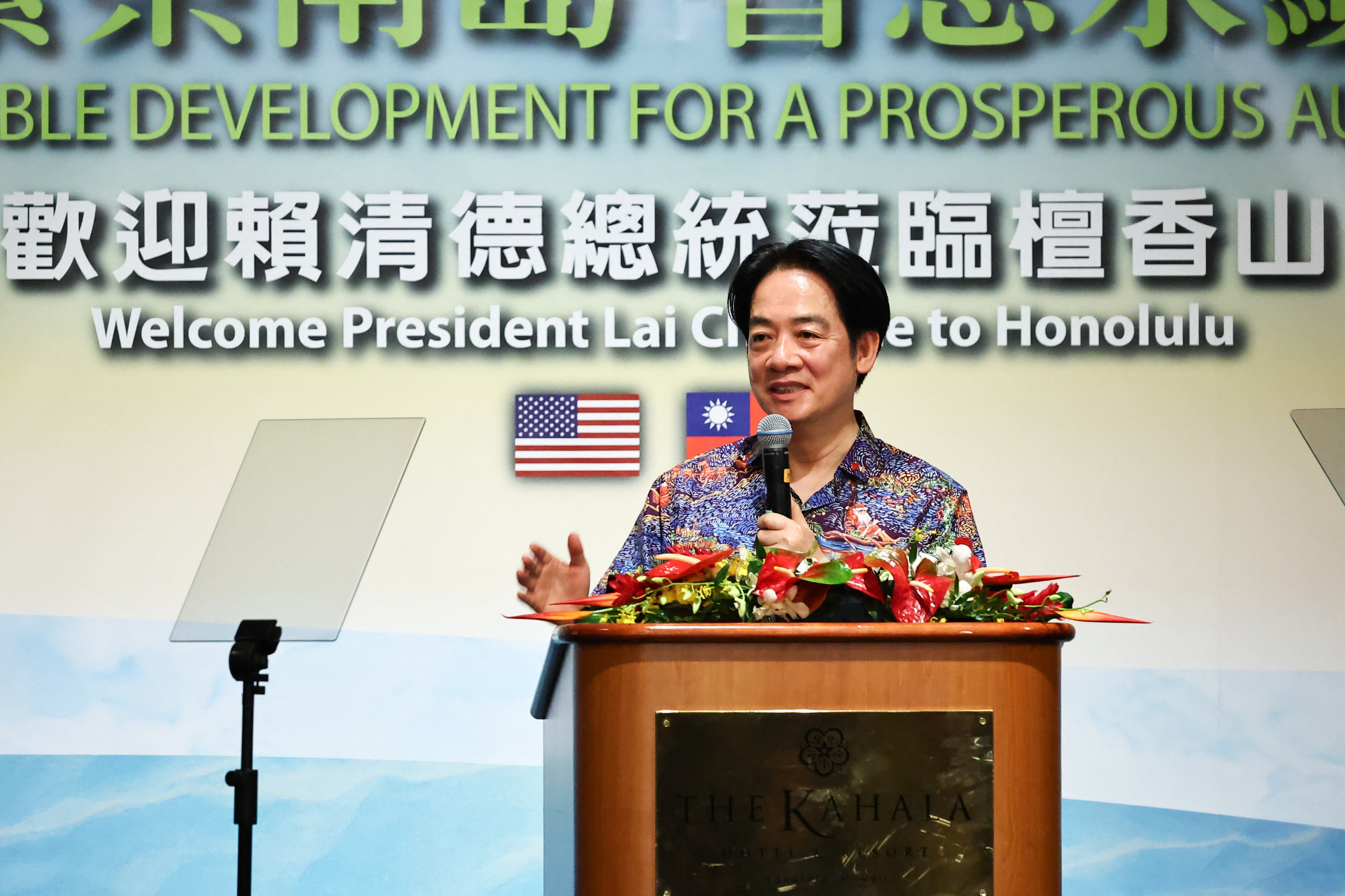 El presidente de Taiwán, Lai Ching-te, habla en un evento en Honolulu frente a un atril decorado con flores, con banderas de Taiwán y Estados Unidos al fondo.