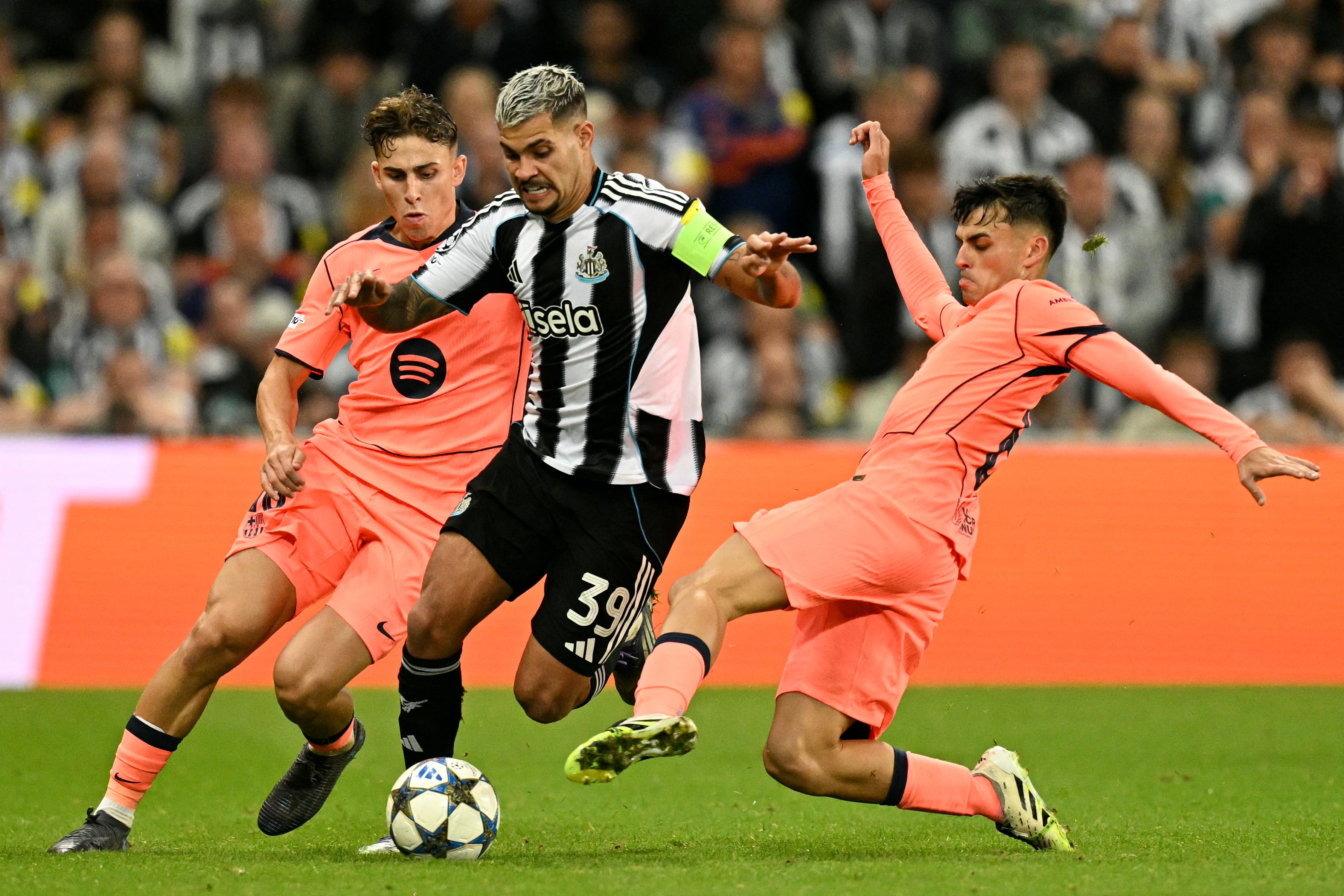 El brasileño del Newcastle Bruno Guimaraes controla el balón ante la marca de Pedri, del Barcelona, en duelo por la primera jornada de la nueva Champions League.