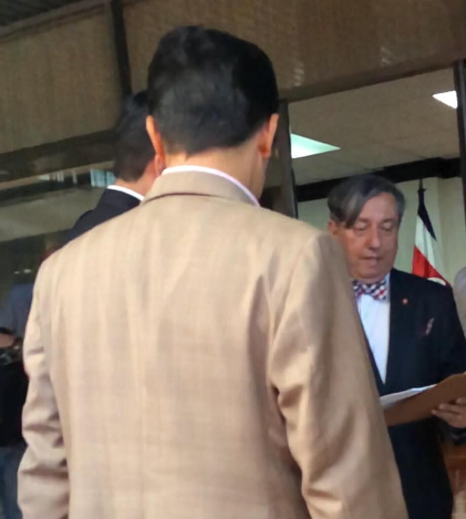 Álvaro Burgos, magistrado de la Sala Tercera (de frente), lee la orden de allanamiento al presidente Carlos Alvarado (izquierda, de espaldas) y a su abogado, Róger Guevara. Foto: Cortesía.