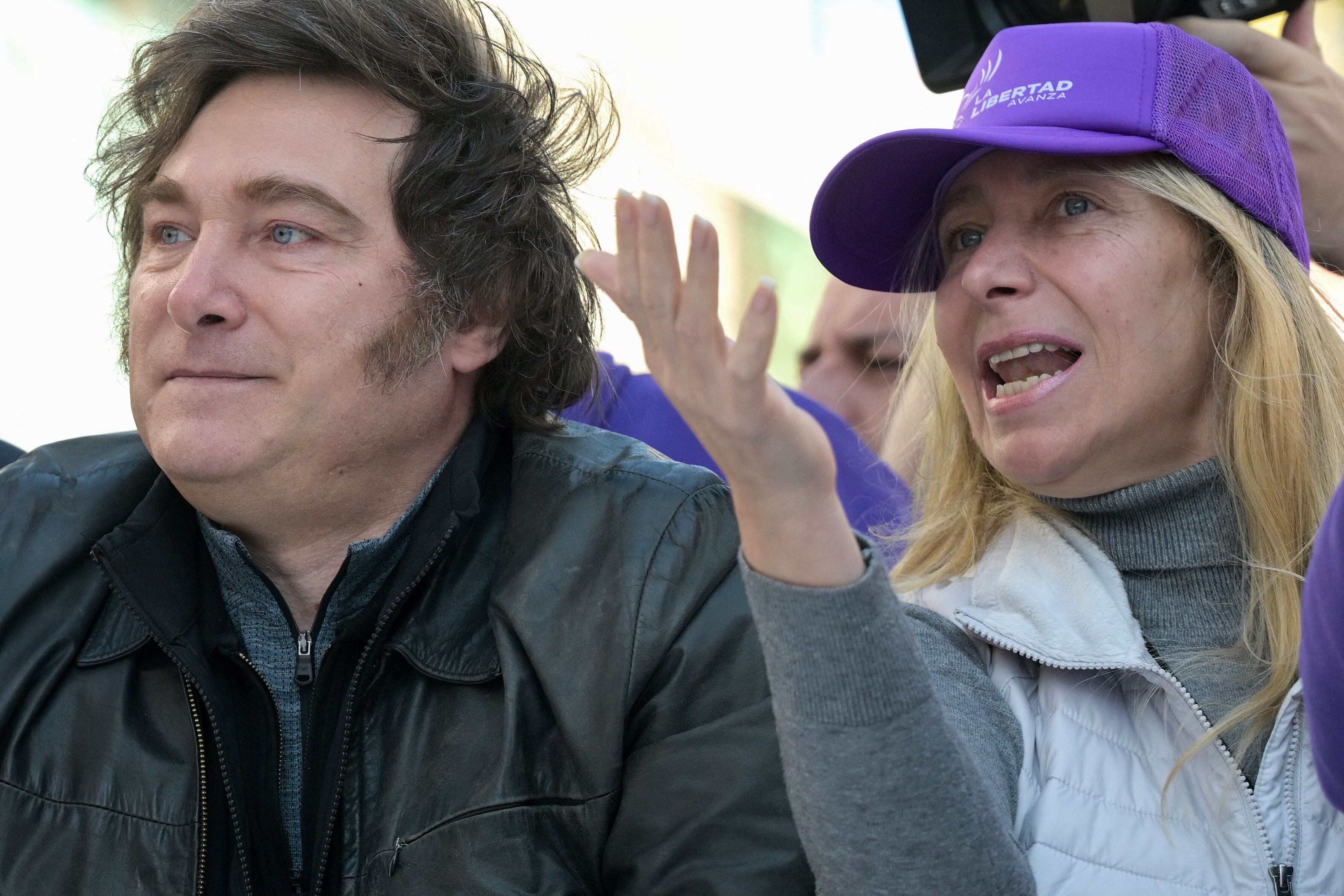 Argentina's President Javier Milei (L) and his sister, Secretary General of the Presidency Karina Milei, lead a motorcade during a rally ahead of legislative provincial elections in Lomas de Zamora, Buenos Aires province, Argentina, on August 27, 2025. Argentine President Javier Milei was evacuated from a campaign event on the southern outskirts of Buenos Aires after protesters threw objects at the vehicle in which he was traveling, amid controversy over an alleged corruption case involving the government. (Photo by JUAN MABROMATA / AFP)