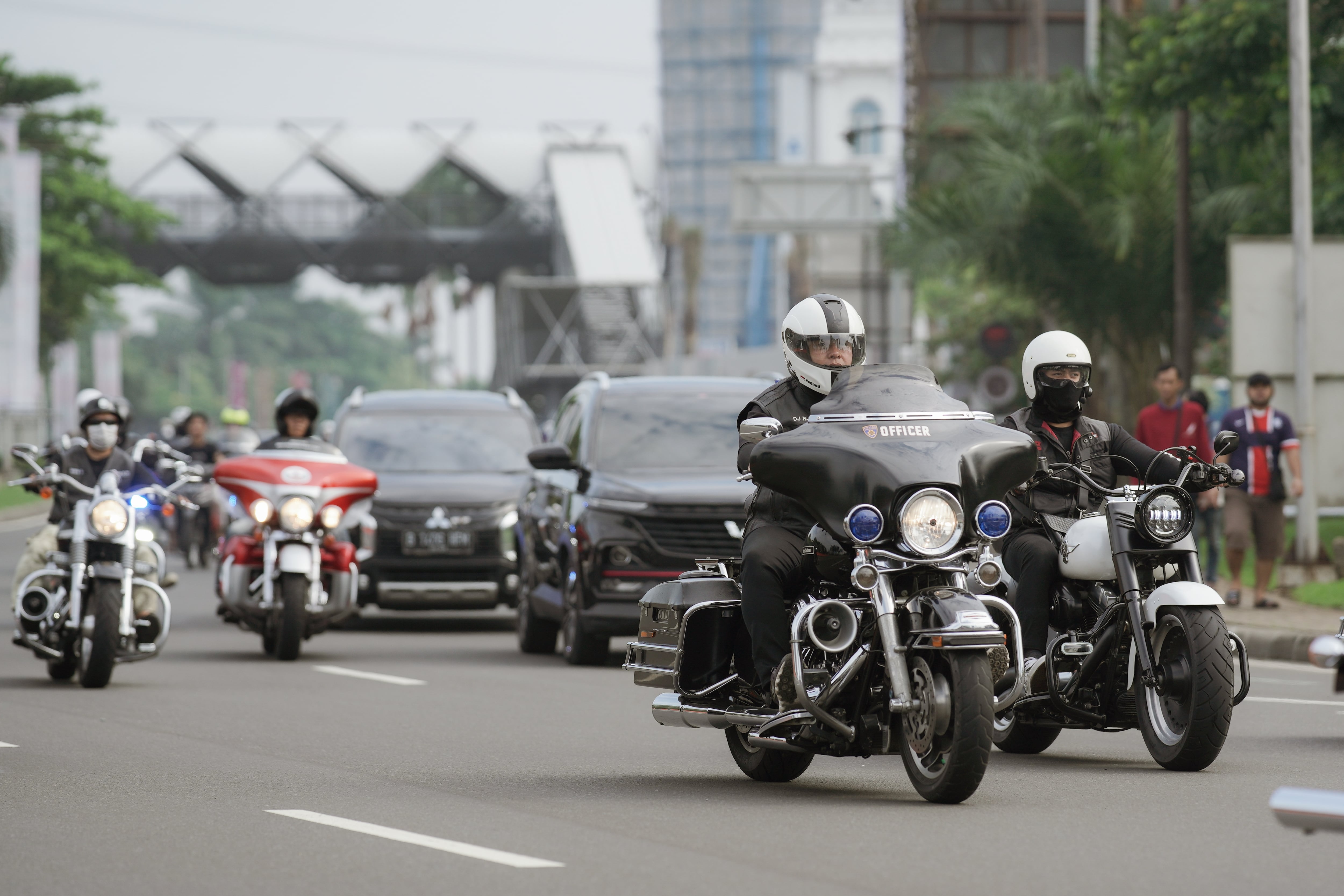 Políticos en carretera, escoltados por otros vehículos, al tiempo que motocicletas suenan sirenas y les abren paso